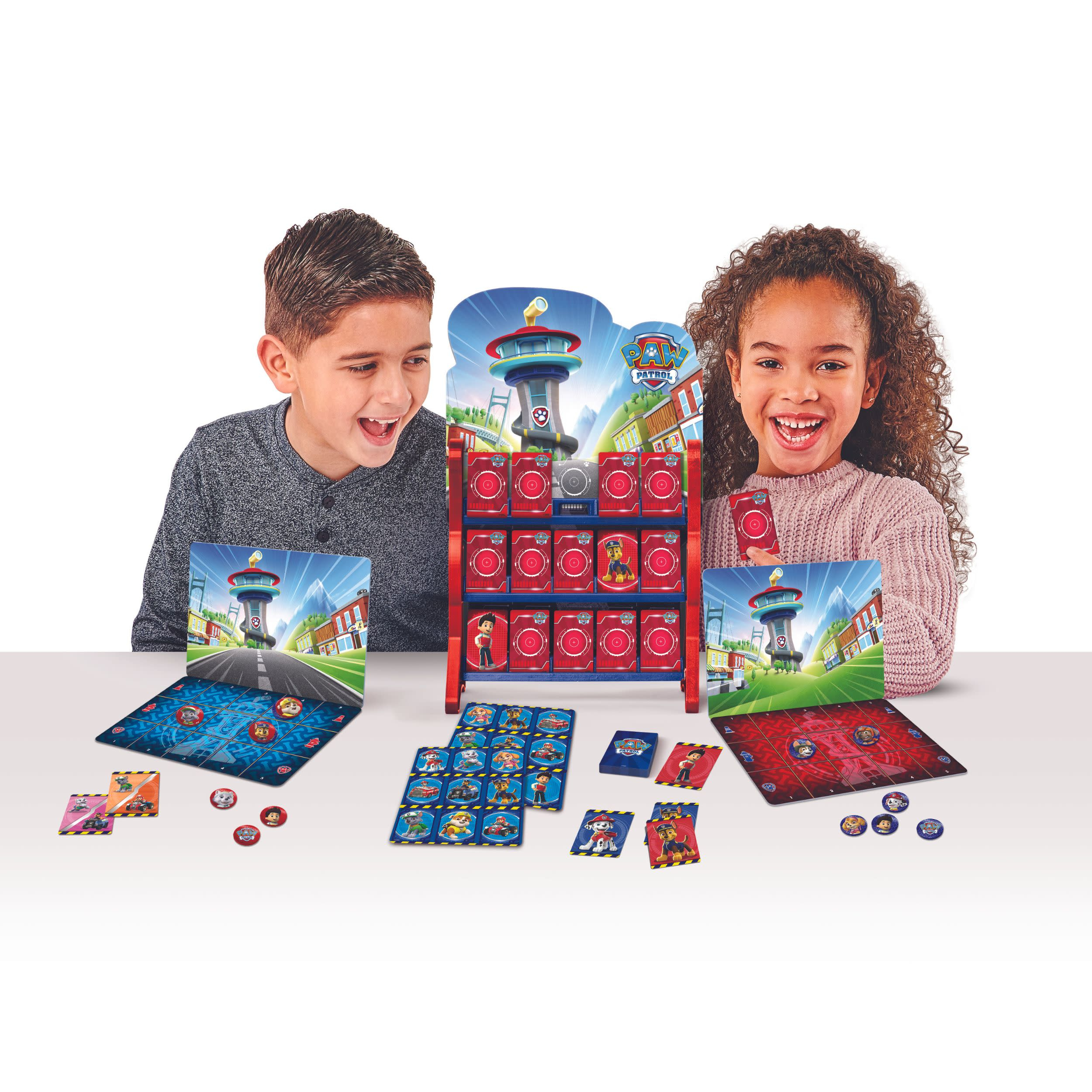 Zwei Kinder lächeln und spielen ein Paw Patrol-Spiel mit Spielbrettern und Karten.