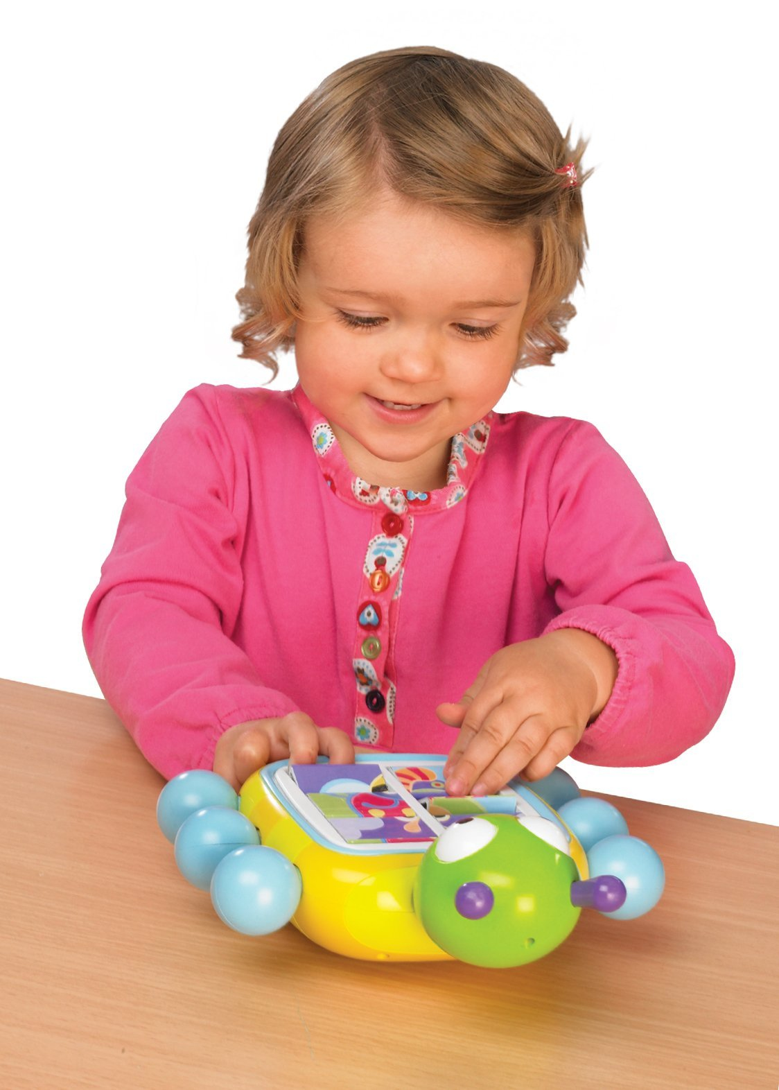 Mała dziewczynka bawi się układanką w kształcie robaka. Zabawka ma zieloną głowę, niebieskie kulki i żółte ciało.