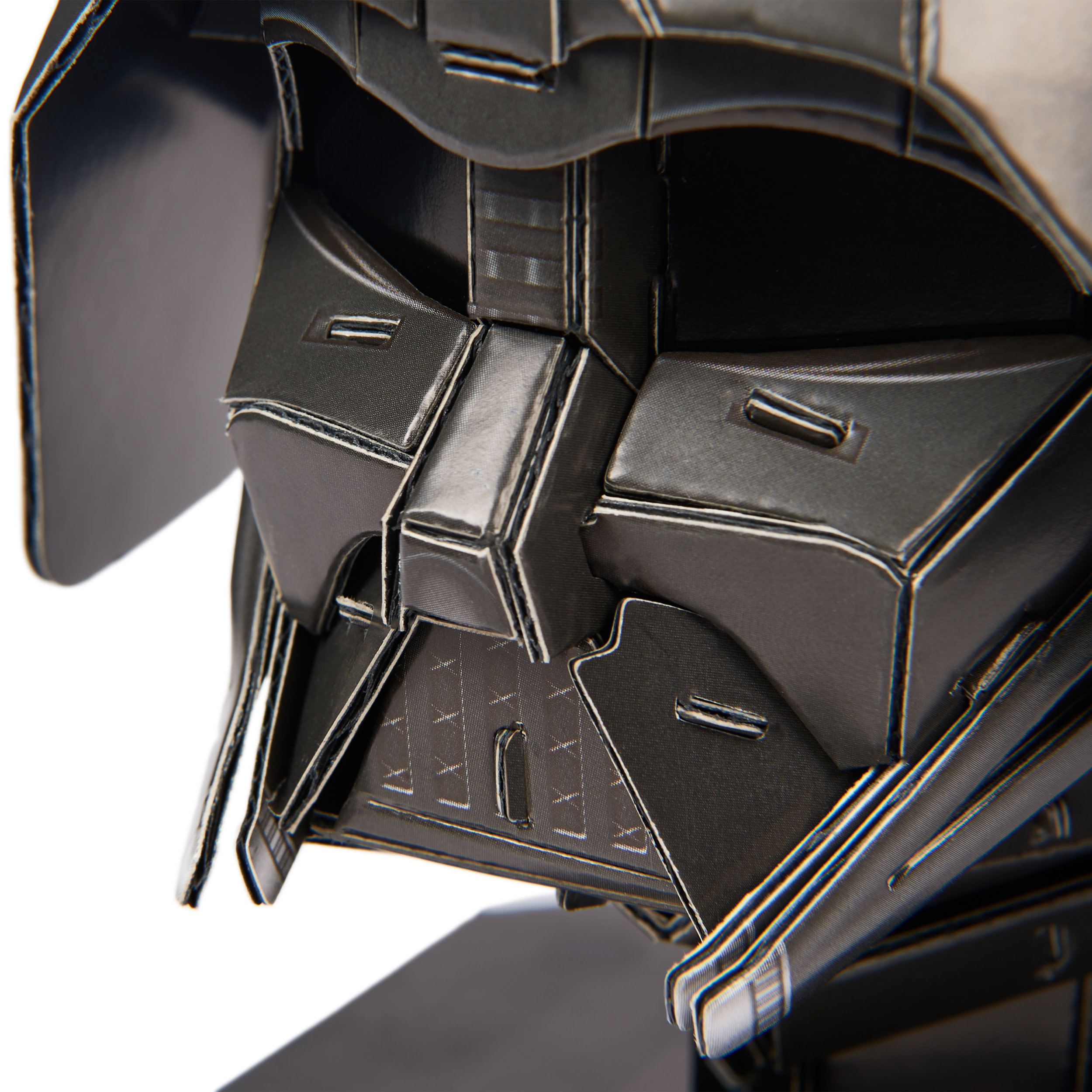 Close-up of Darth Vader helmet puzzle. Black, angular with intricate details.
