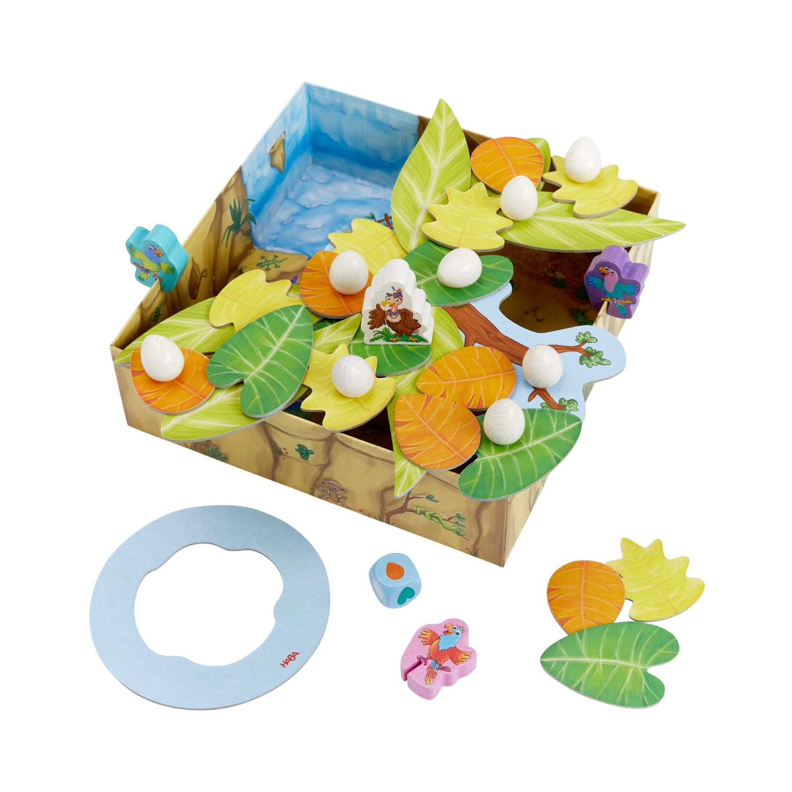 Jeu pour enfants avec une boîte, un arbre en bois, des œufs, des feuilles, des figurines et un dé.