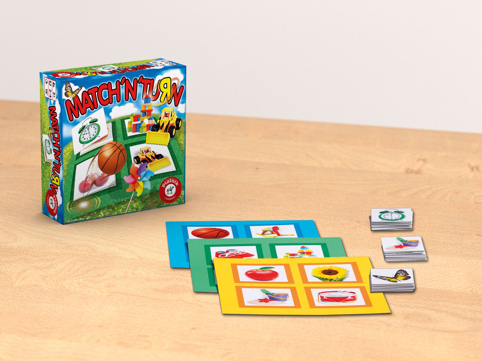 Spiel in einer Box mit Karten und Bildern. Karten zeigen Bilder einer Uhr, eines Balls und anderer Objekte.