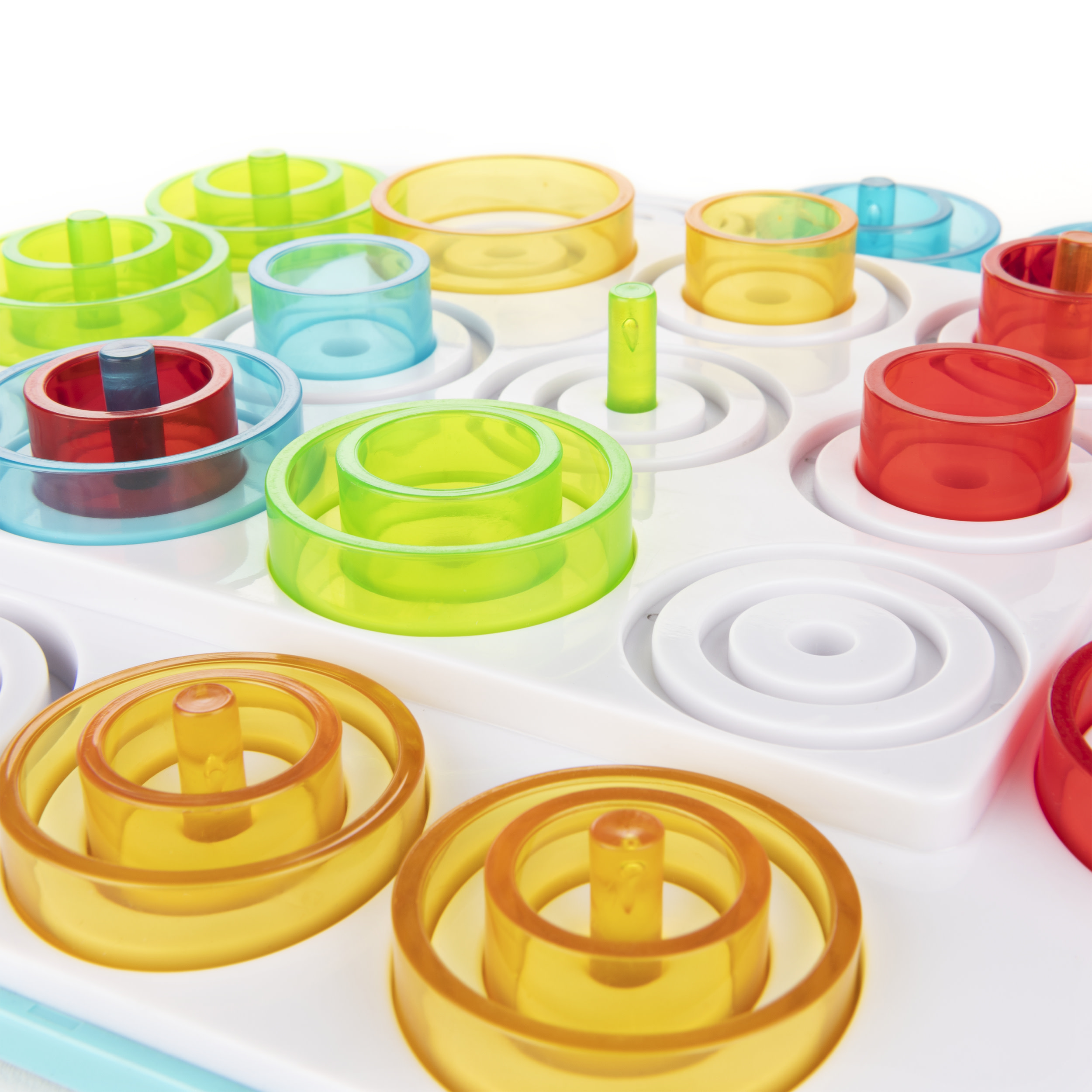 Ein Brettspiel mit bunten Ringen. Das Brett hat Stifte, auf denen Ringe gestapelt sind. Weißer Hintergrund.