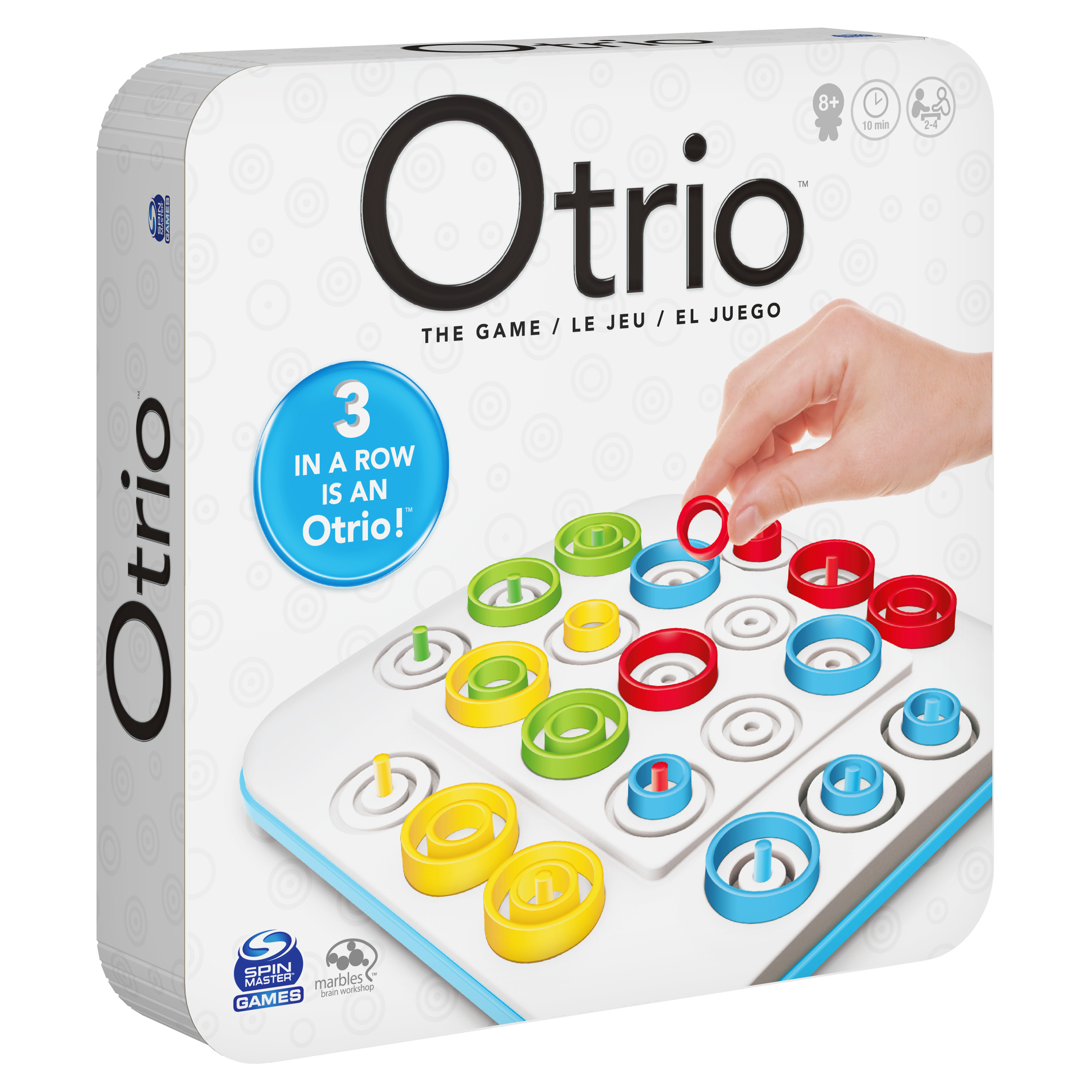 Eine Schachtel des Otrio-Spiels. Die Schachtel zeigt Spielsteine und eine Hand, die einen Ring platziert. Weißer Hintergrund.