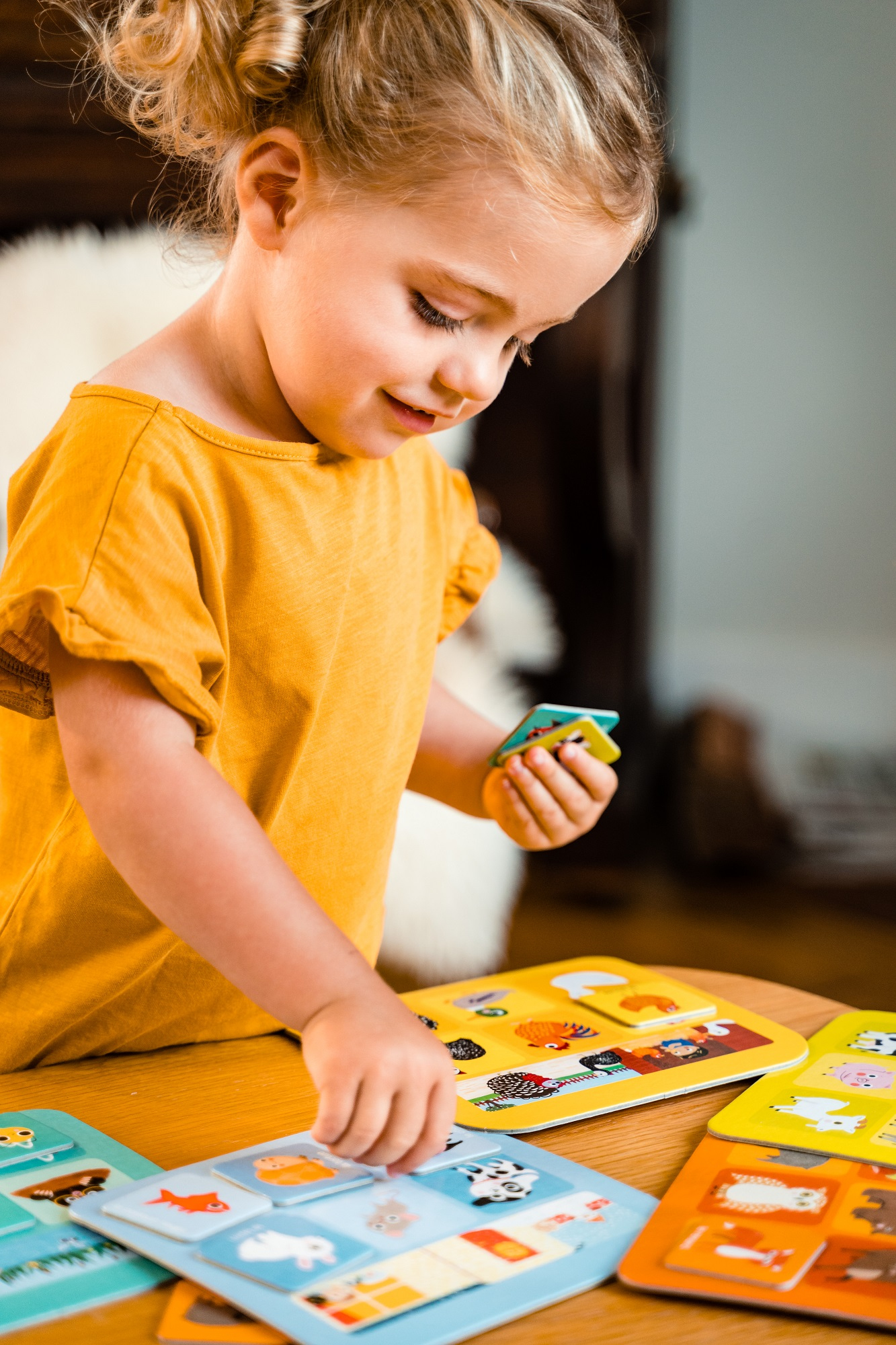 Mała dziewczynka gra w grę polegającą na dopasowywaniu zwierząt.
