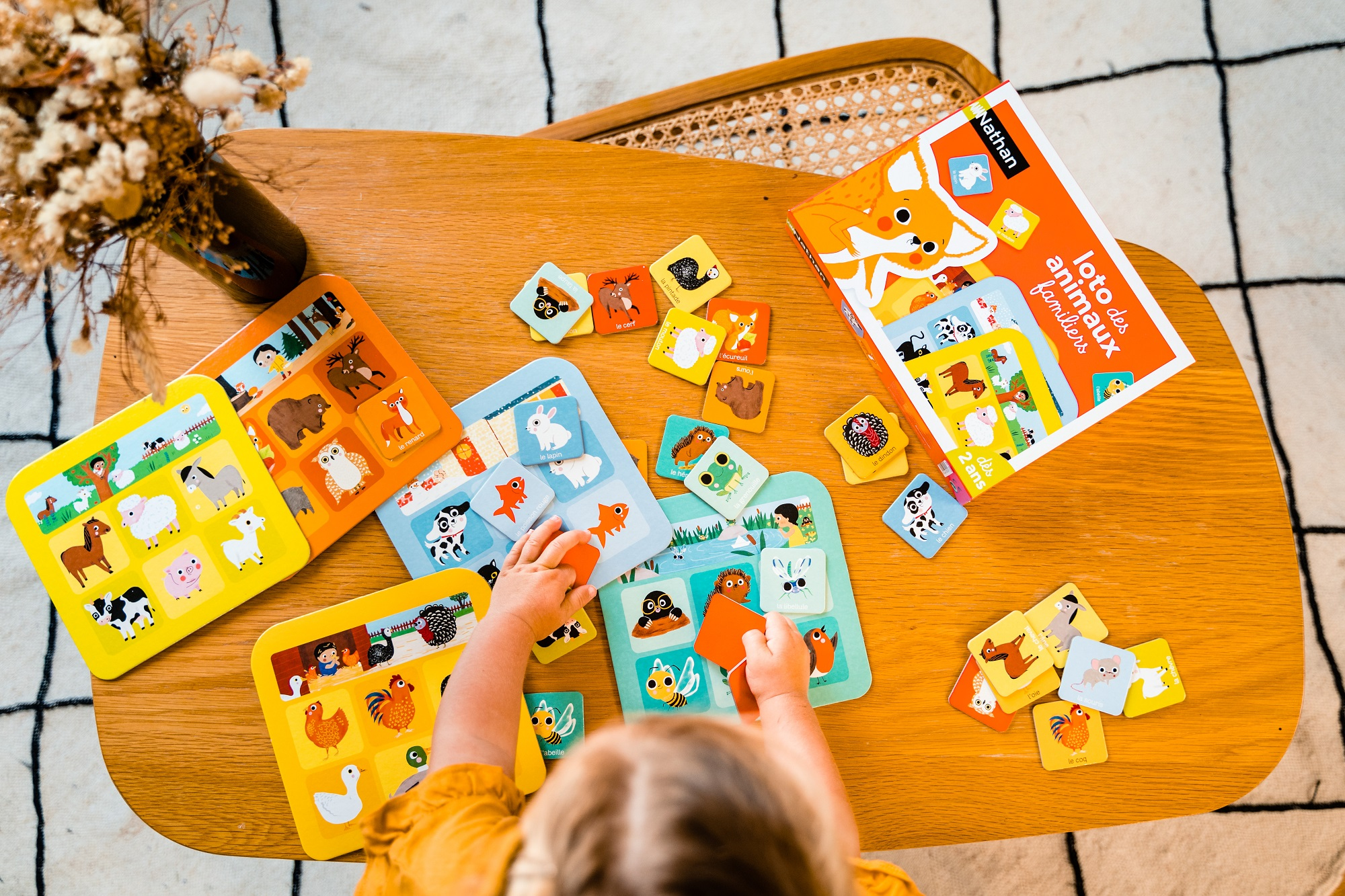 Dziecko gra w grę polegającą na dopasowywaniu zwierząt na stole.
