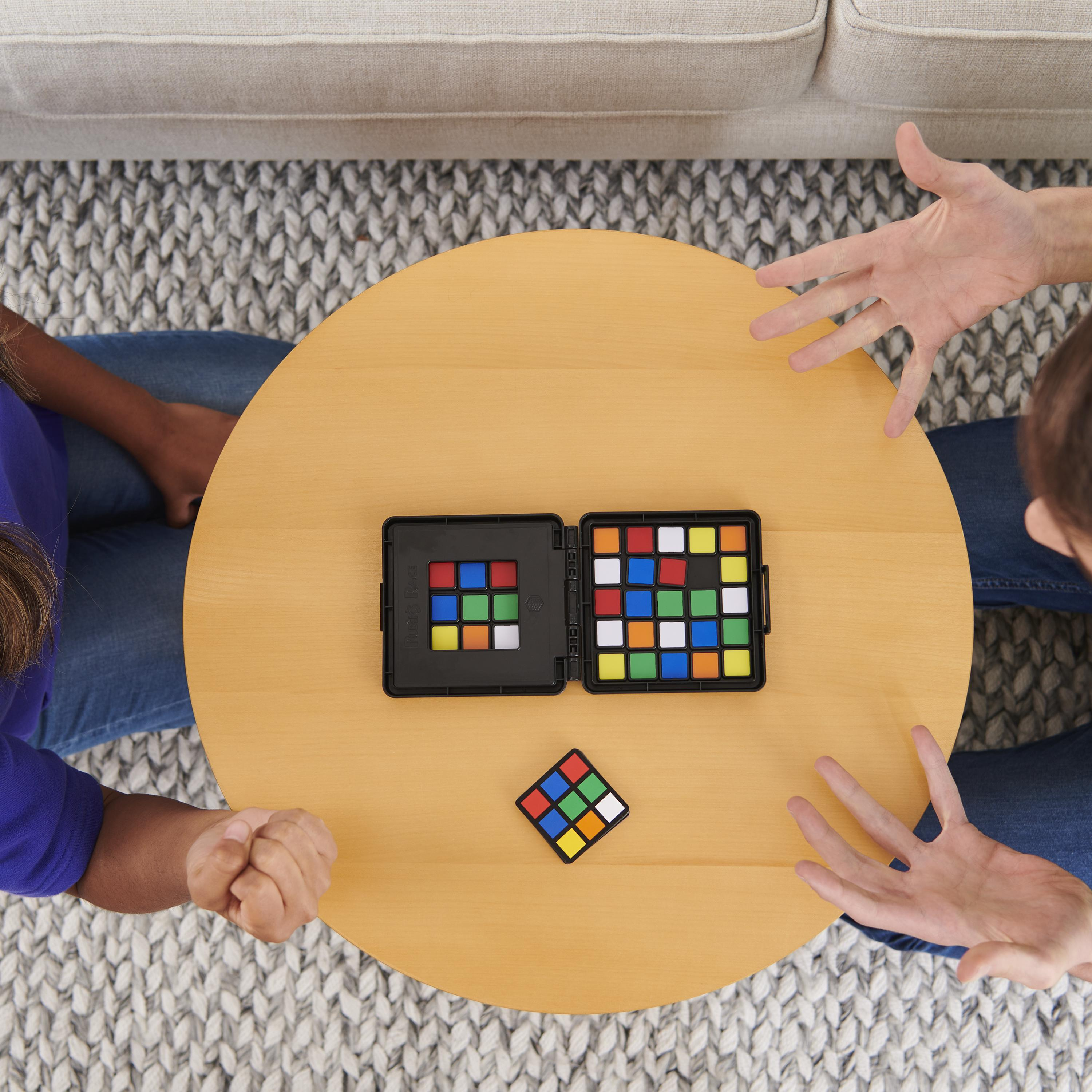 Dwie osoby grają w grę kostki Rubika na stole.