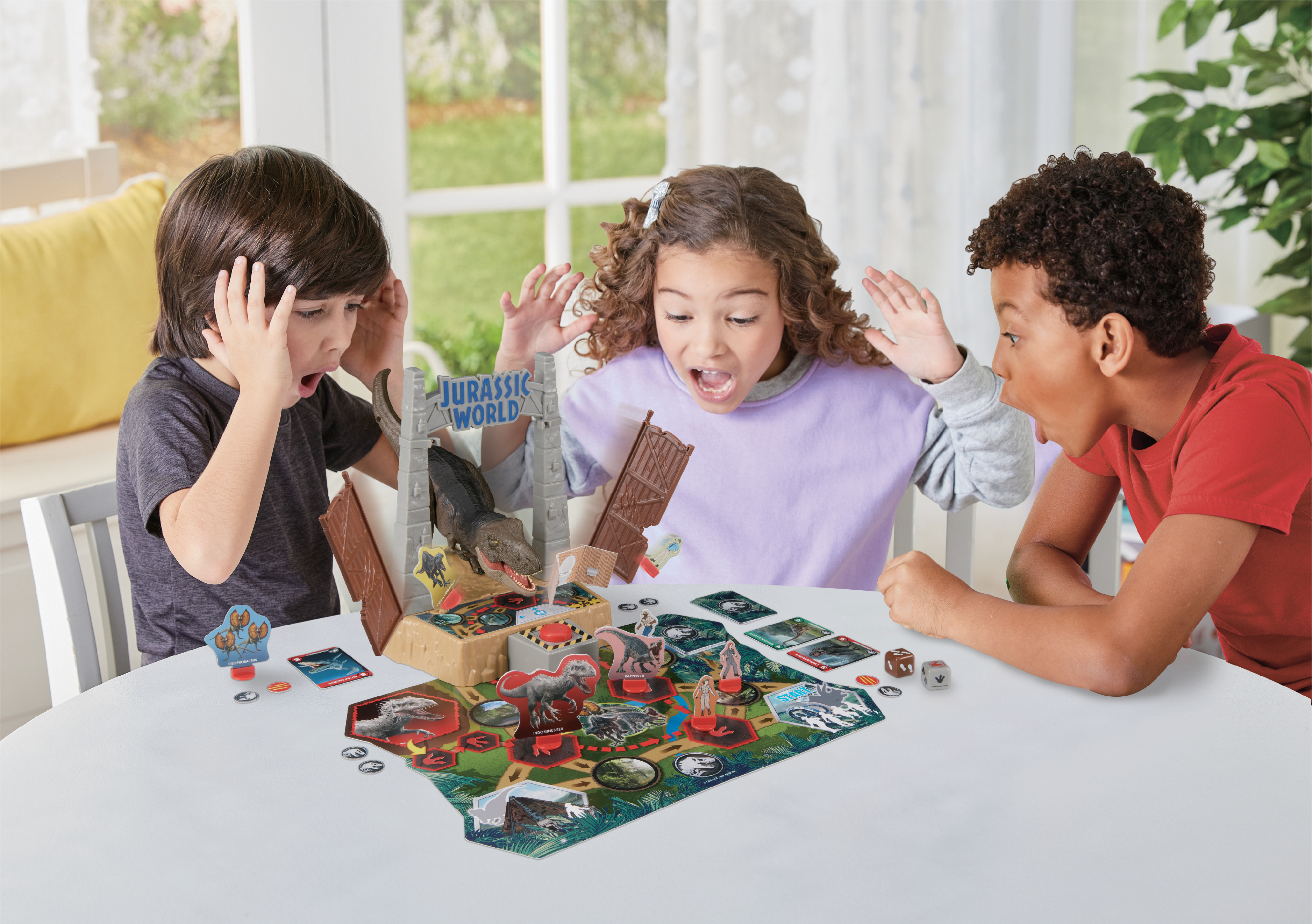 Bambini che reagiscono a un gioco da tavolo di Jurassic World con un dinosauro.