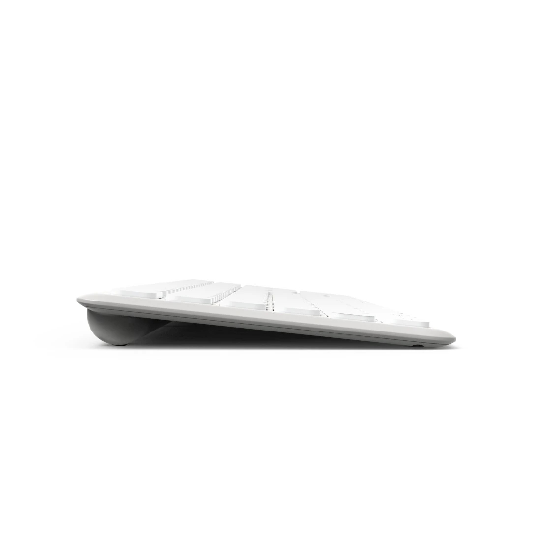Una vista lateral de un teclado blanco. El teclado tiene una ligera inclinación hacia atrás.