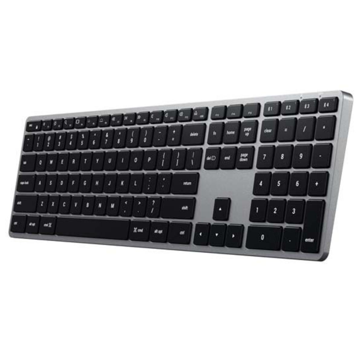 Teclado plateado con teclas negras. Está en ángulo y sobre un fondo blanco.