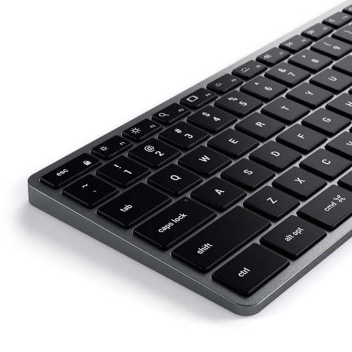 Primer plano de un teclado plateado con teclas negras. Fondo blanco.