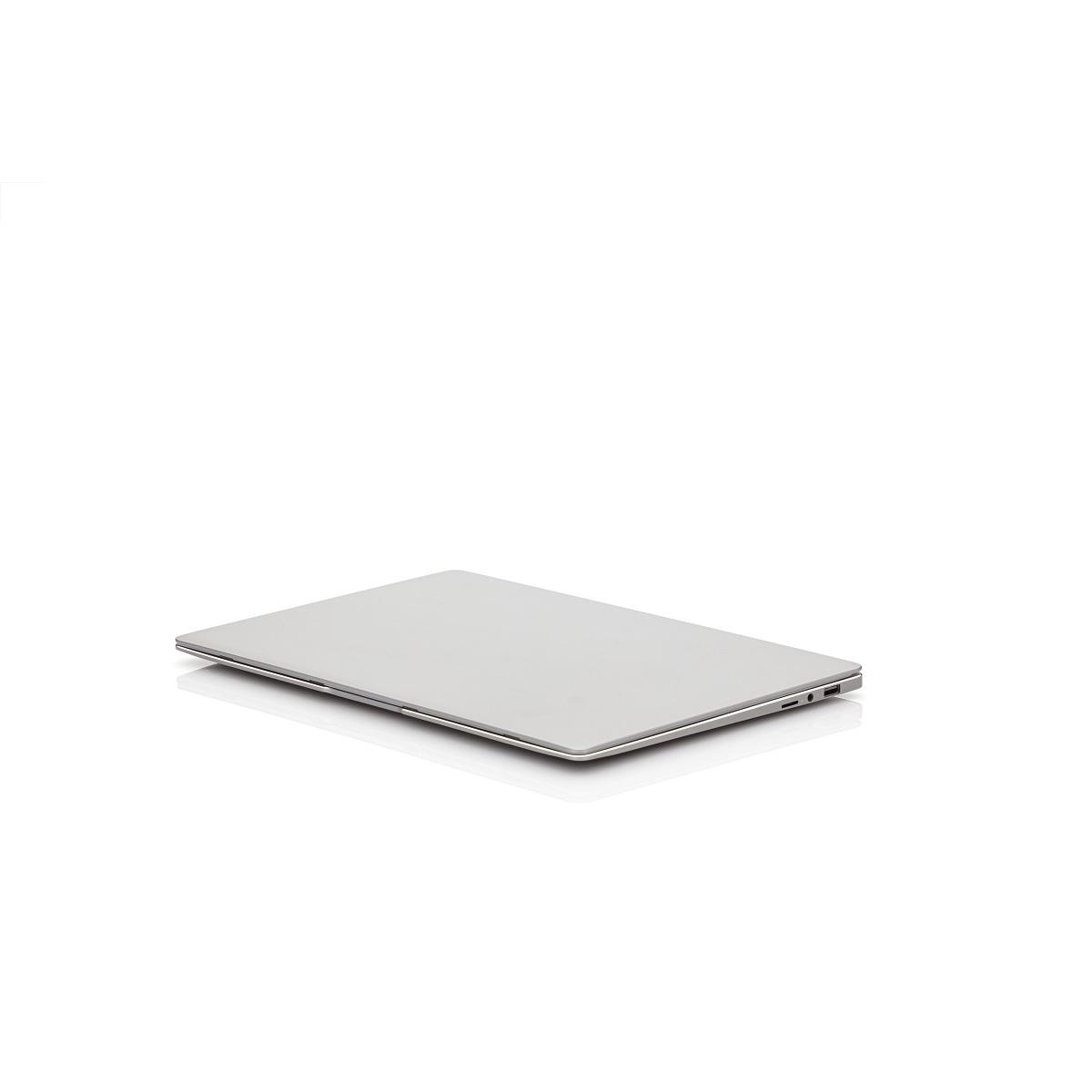 Laptop argentato, chiuso, su una superficie bianca. Leggera riflessione visibile.