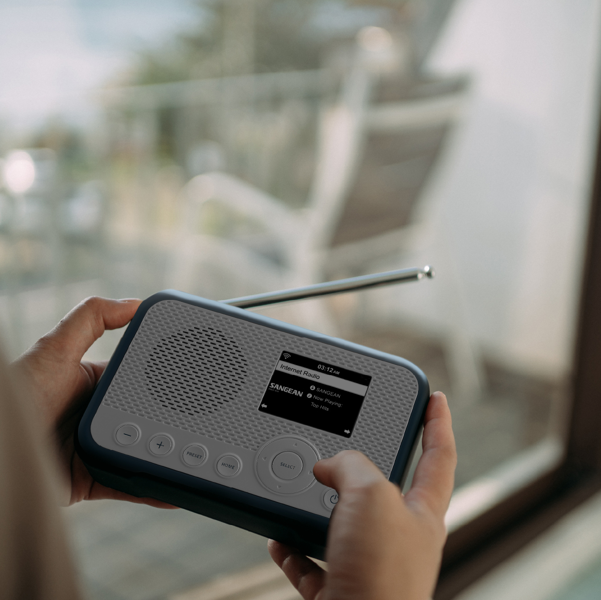 Osoba trzymająca niebiesko-białe radio. Ma ekran i przyciski.