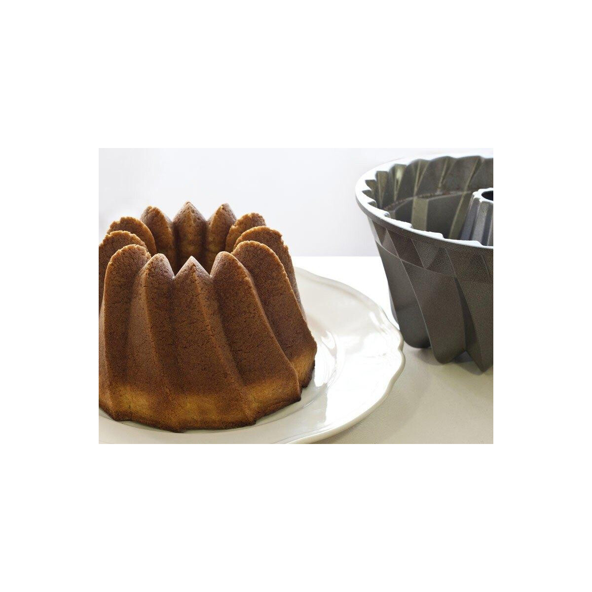 Beyaz tabakta Bundt kek, yanında boş bir Bundt kalıbı.