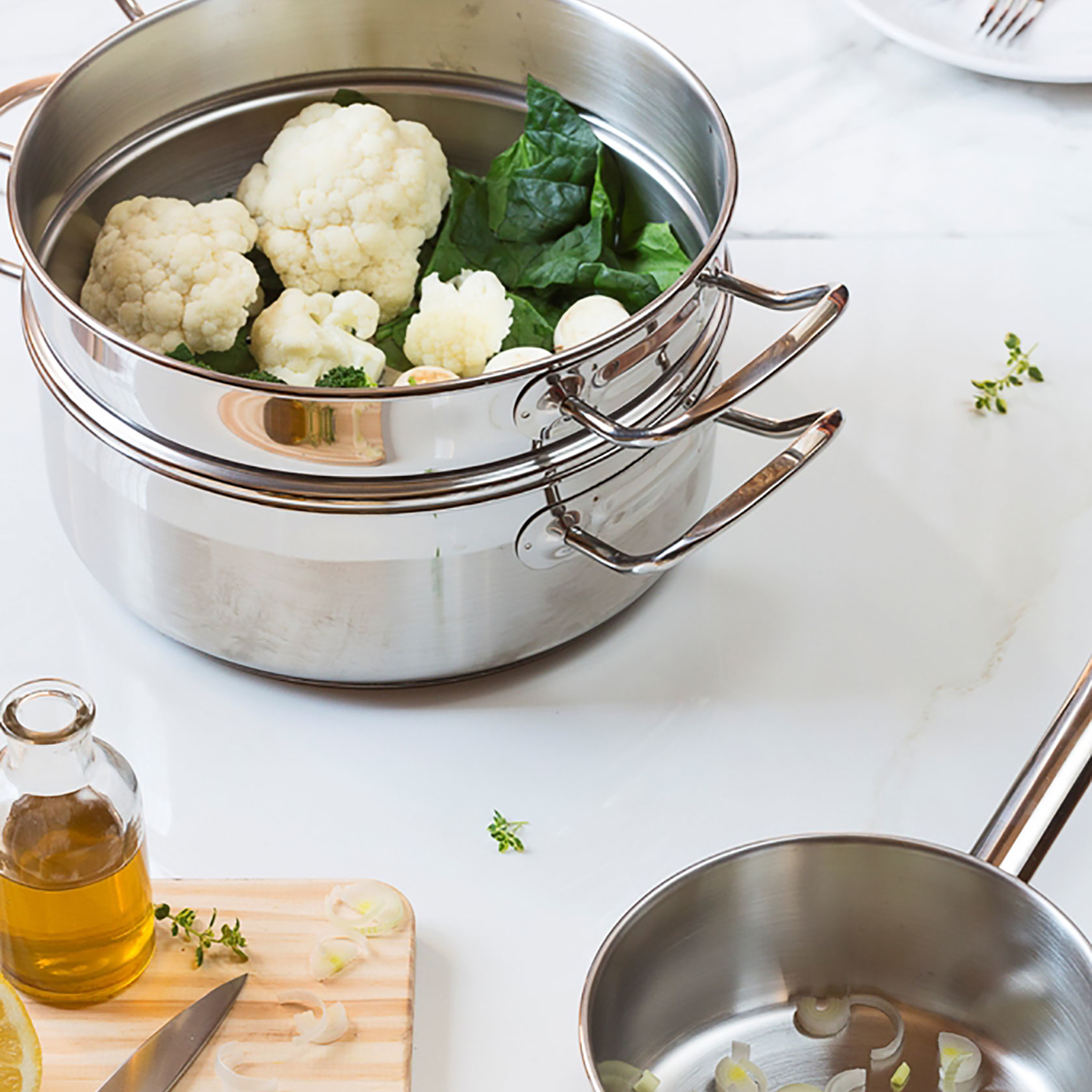 Olla humeante con coliflor y espinacas, con aceite de oliva, limón y cuchillo.