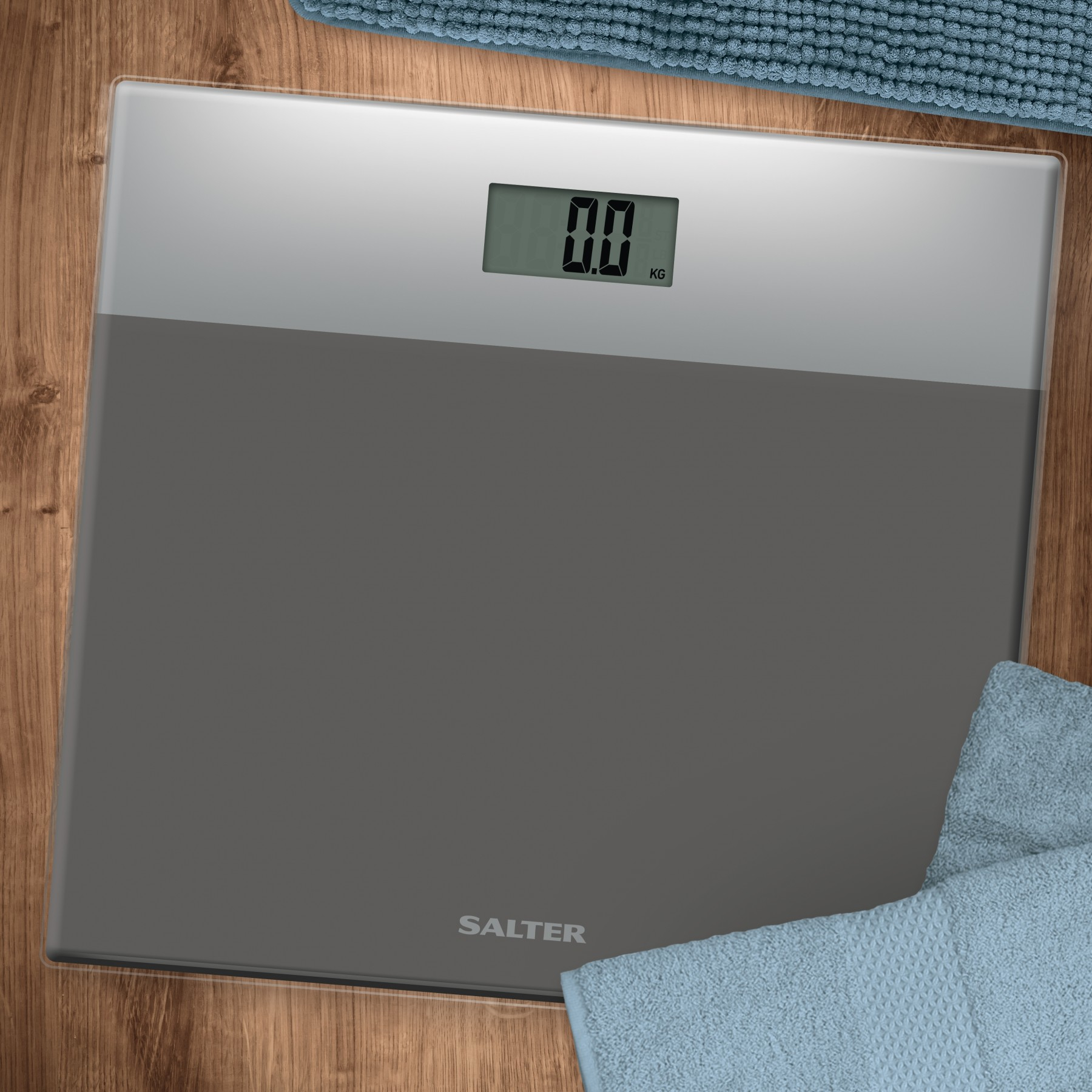 Una bilancia digitale su una superficie di legno con asciugamani intorno. La bilancia indica 0,0 kg.