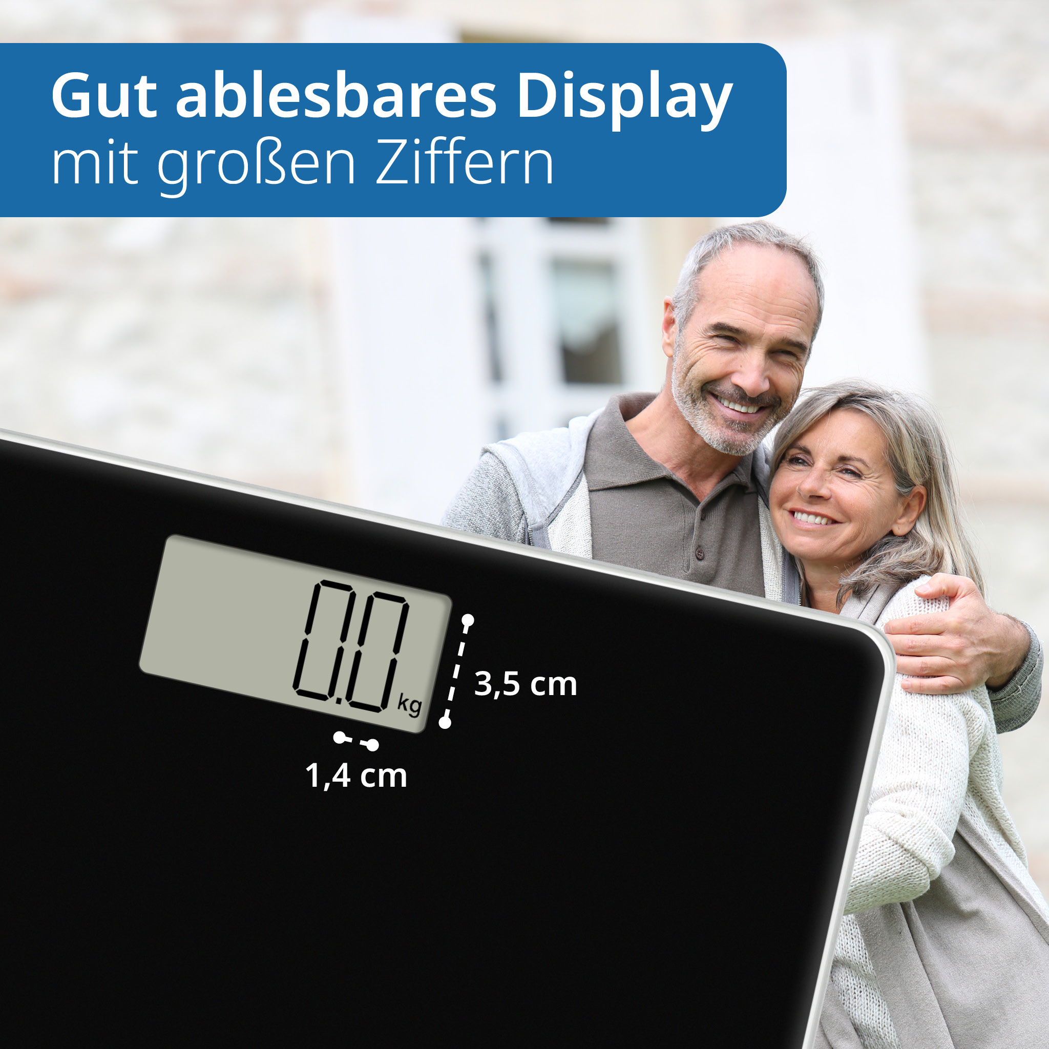 Una bilancia digitale nera con una coppia sorridente sullo sfondo. Lo schermo mostra 0,0 kg.