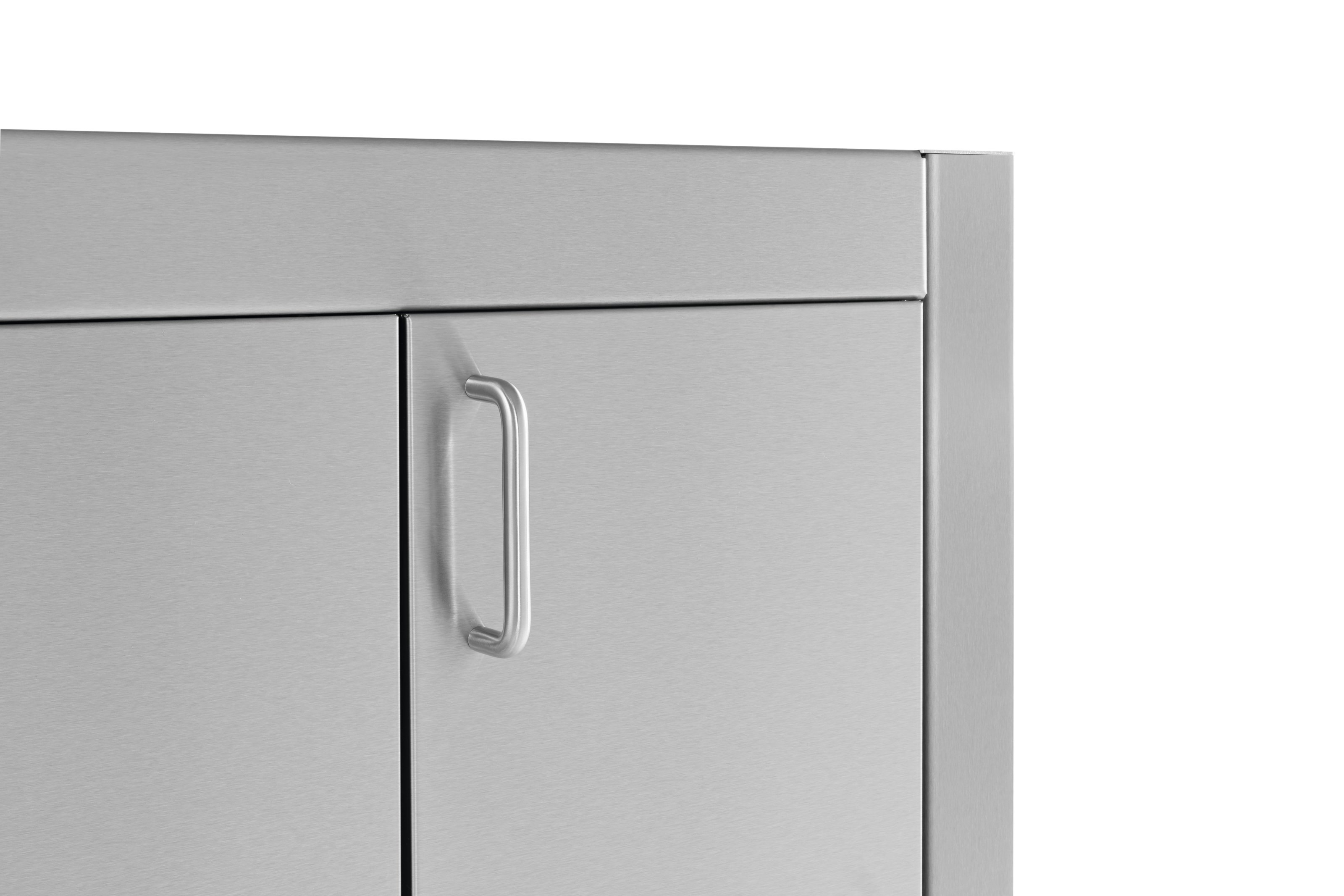 Szczegół wózka kuchennego ze stali nierdzewnej. Pokazuje uchwyt na drzwiach szafki. Białe tło.