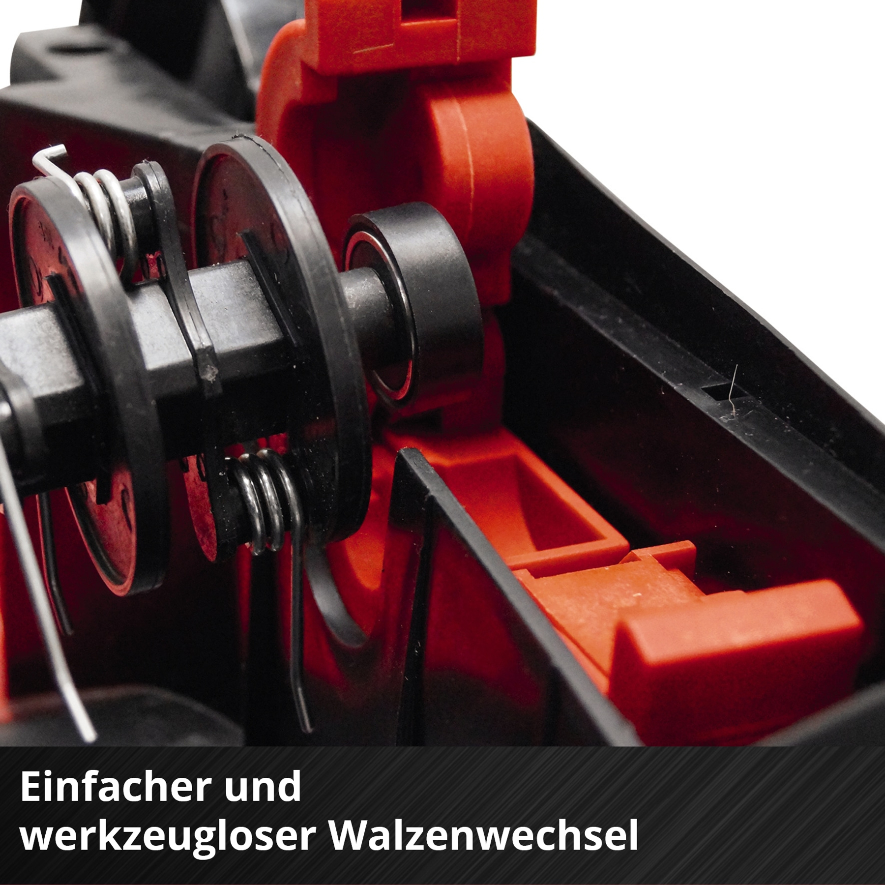 Nahaufnahme von schwarzen Maschinenteilen mit roten Akzenten und Text auf Deutsch.