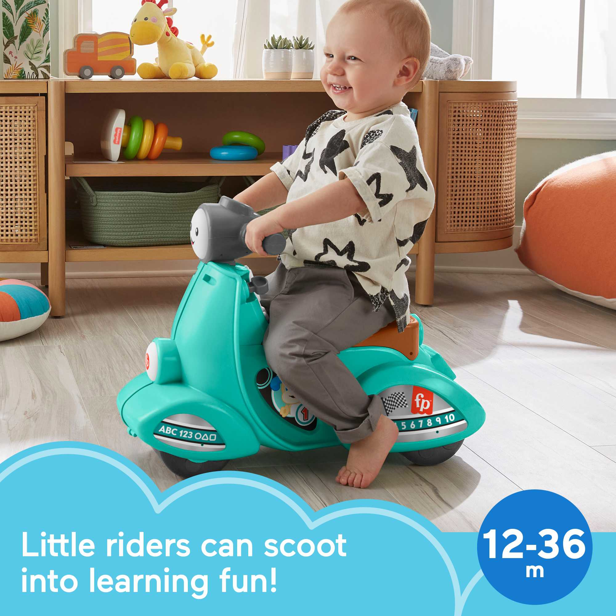 Bambino piccolo su un scooter verde acqua. Sorridente, in casa, vicino ai mobili.