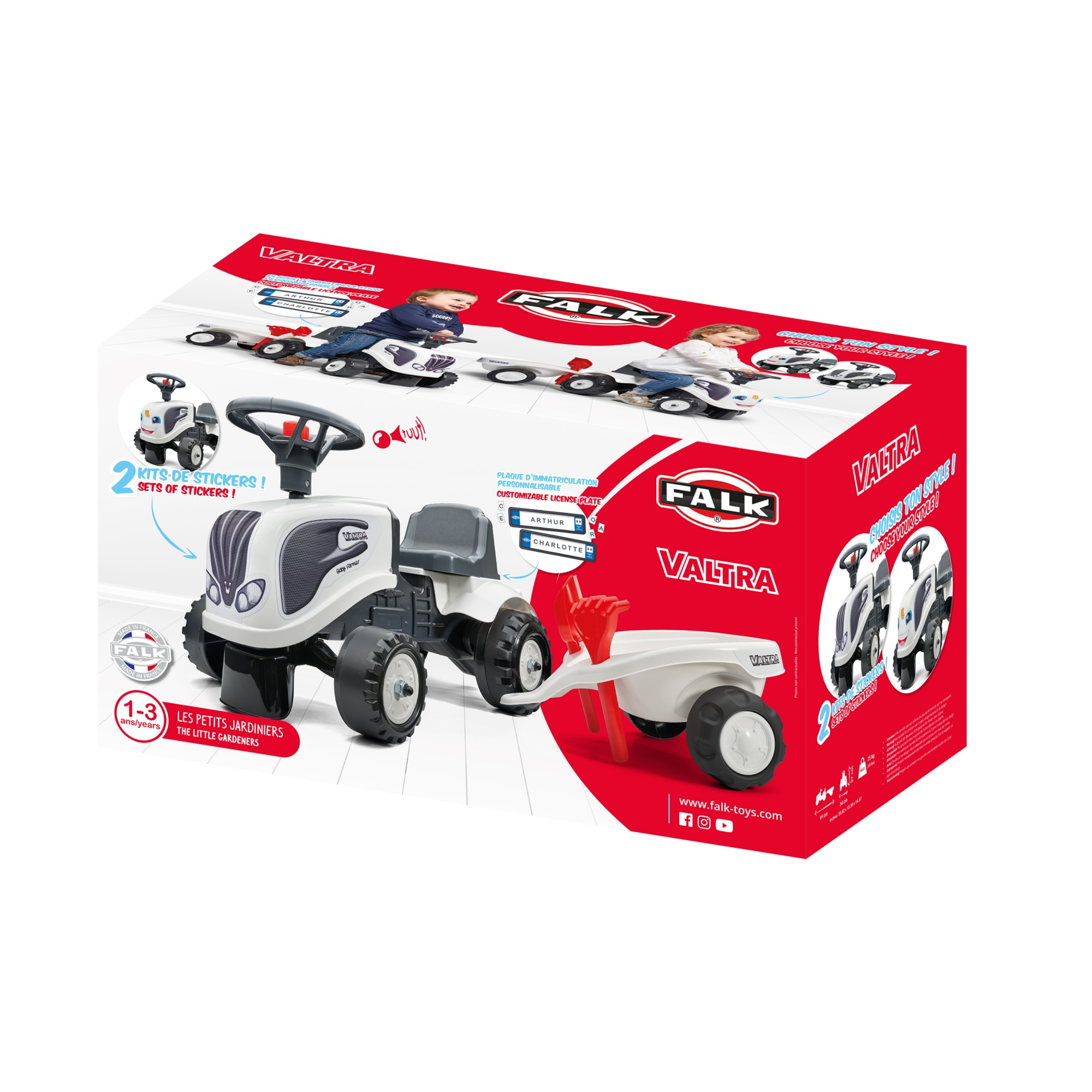 Verpackter Spielzeugtraktor mit Anhänger. Weißer Traktor, roter Anhänger, mit einem Jungen und Mädchen auf der Box.