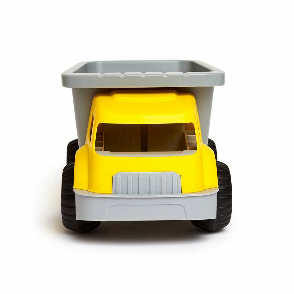Un grande camion ribaltabile giocattolo giallo e grigio. È rivolto allo spettatore su uno sfondo bianco.