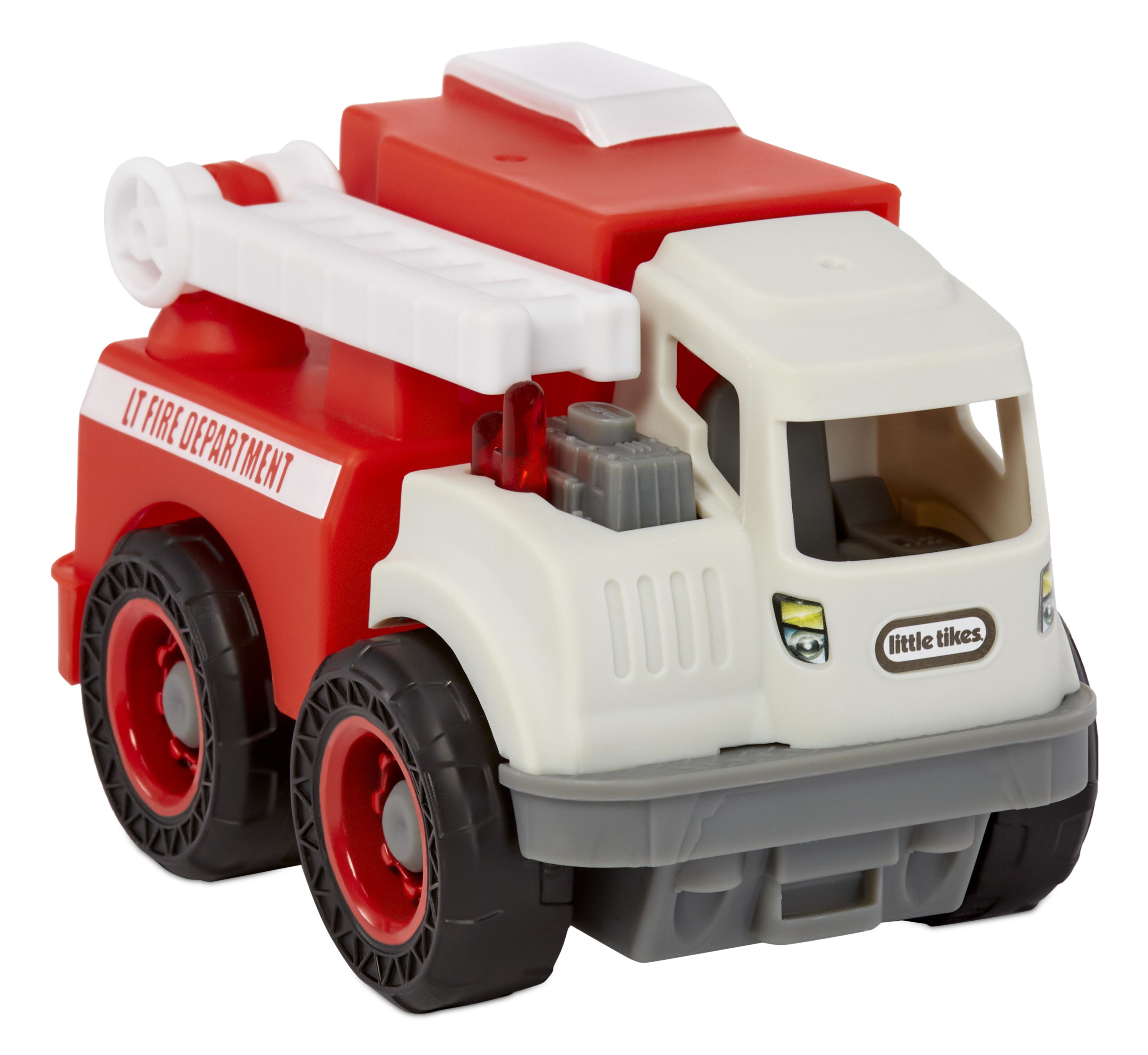 Seitenansicht eines rot-weißen Little Tikes Feuerwehrauto-Spielzeugs. Schwarze Reifen, weiße Leiter und Text 'LT FIRE DEPARTMENT'.