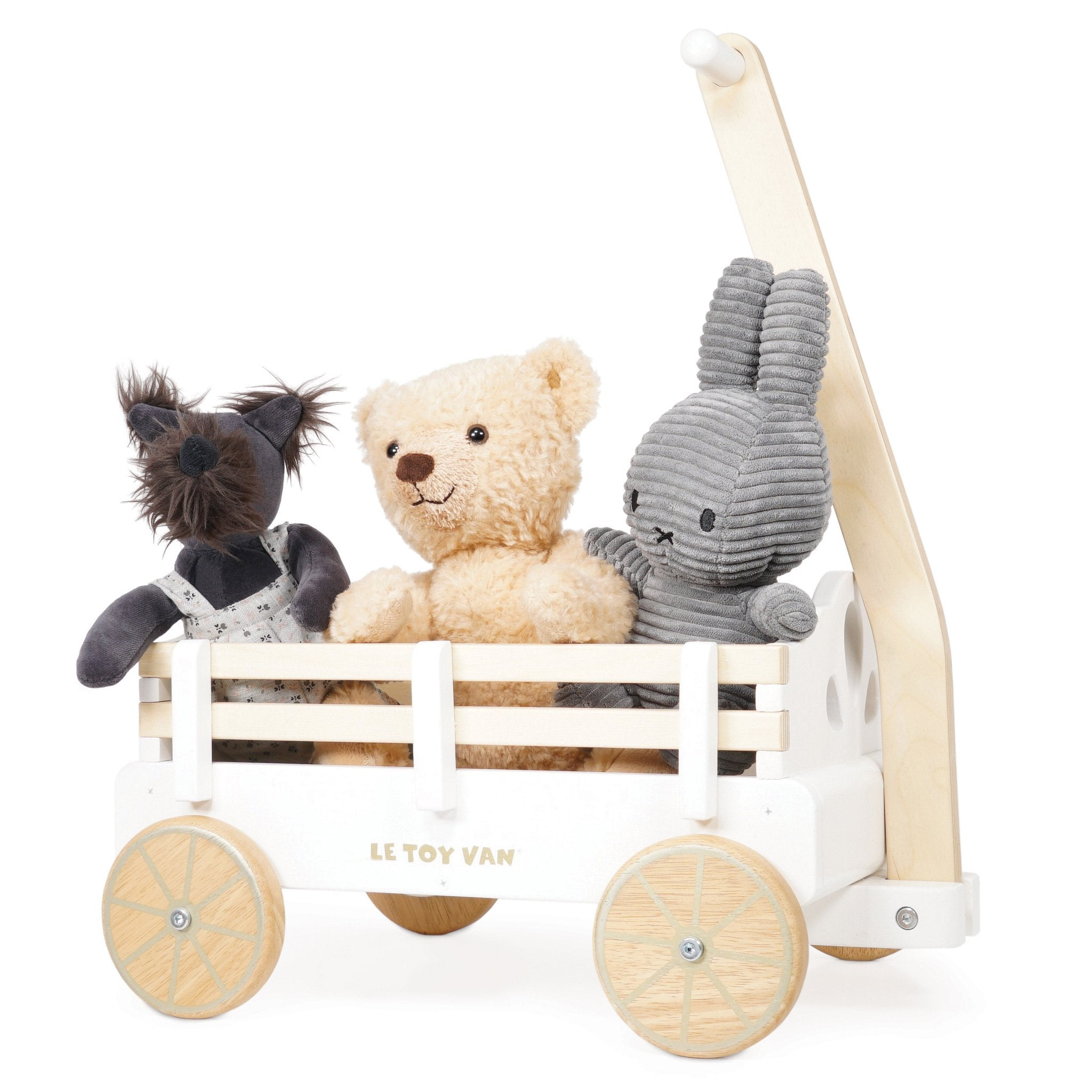 Ein weißer Spielzeugwagen mit drei Stofftieren: einem Hund, einem Teddybär und einem Hasen.