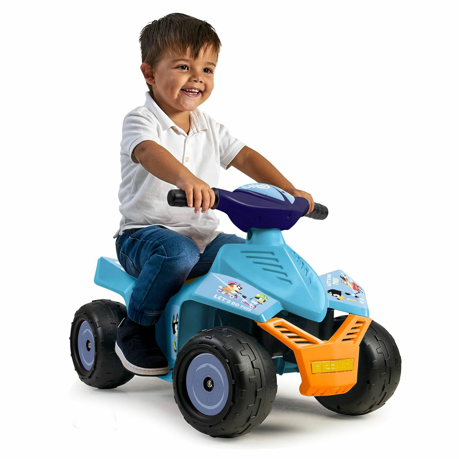 Ein Junge lächelt, während er ein blaues ATV-Spielzeug mit orangefarbener Front fährt.