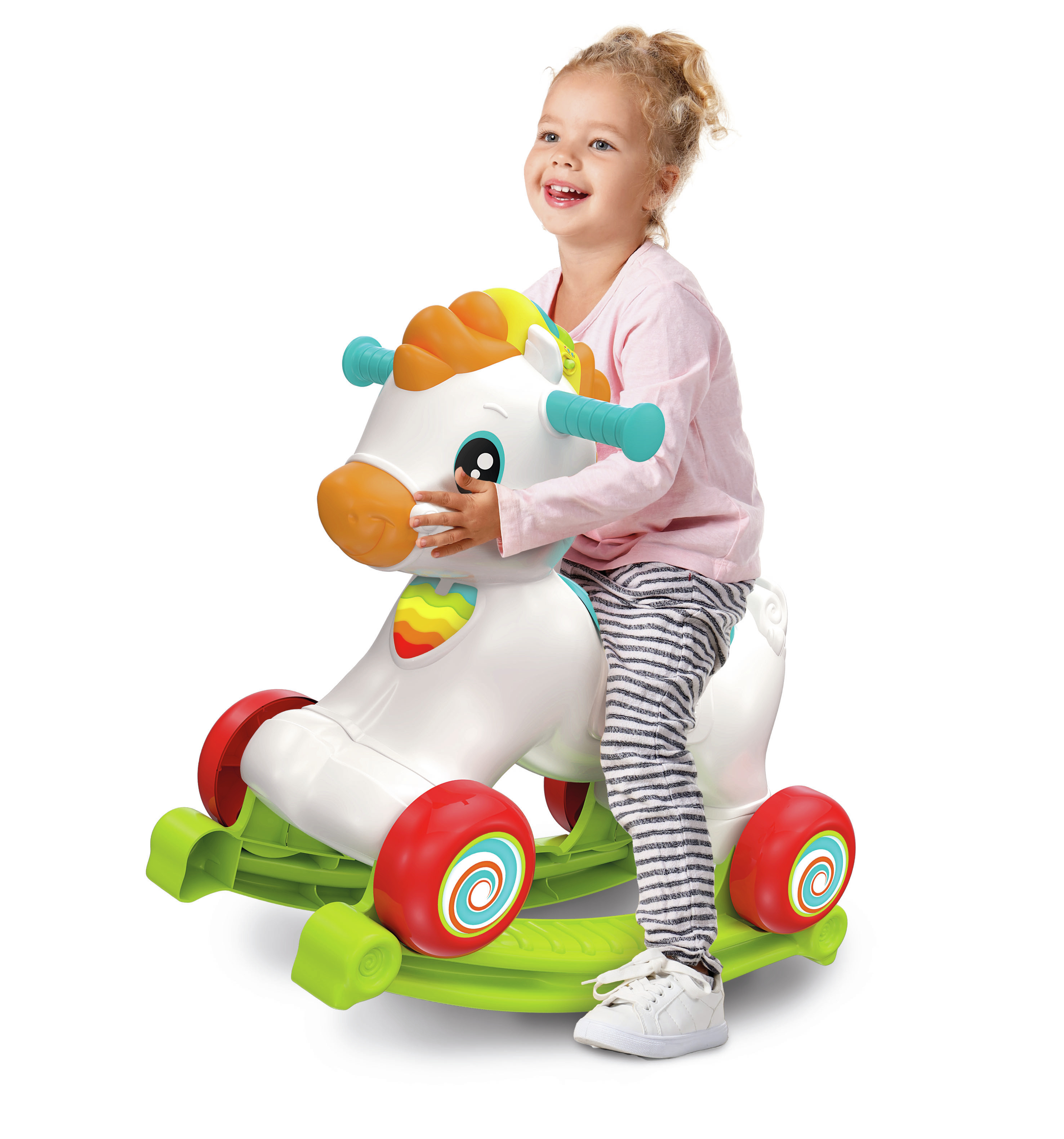 Una bambina cavalca un cavallo giocattolo bianco. Sta sorridendo.