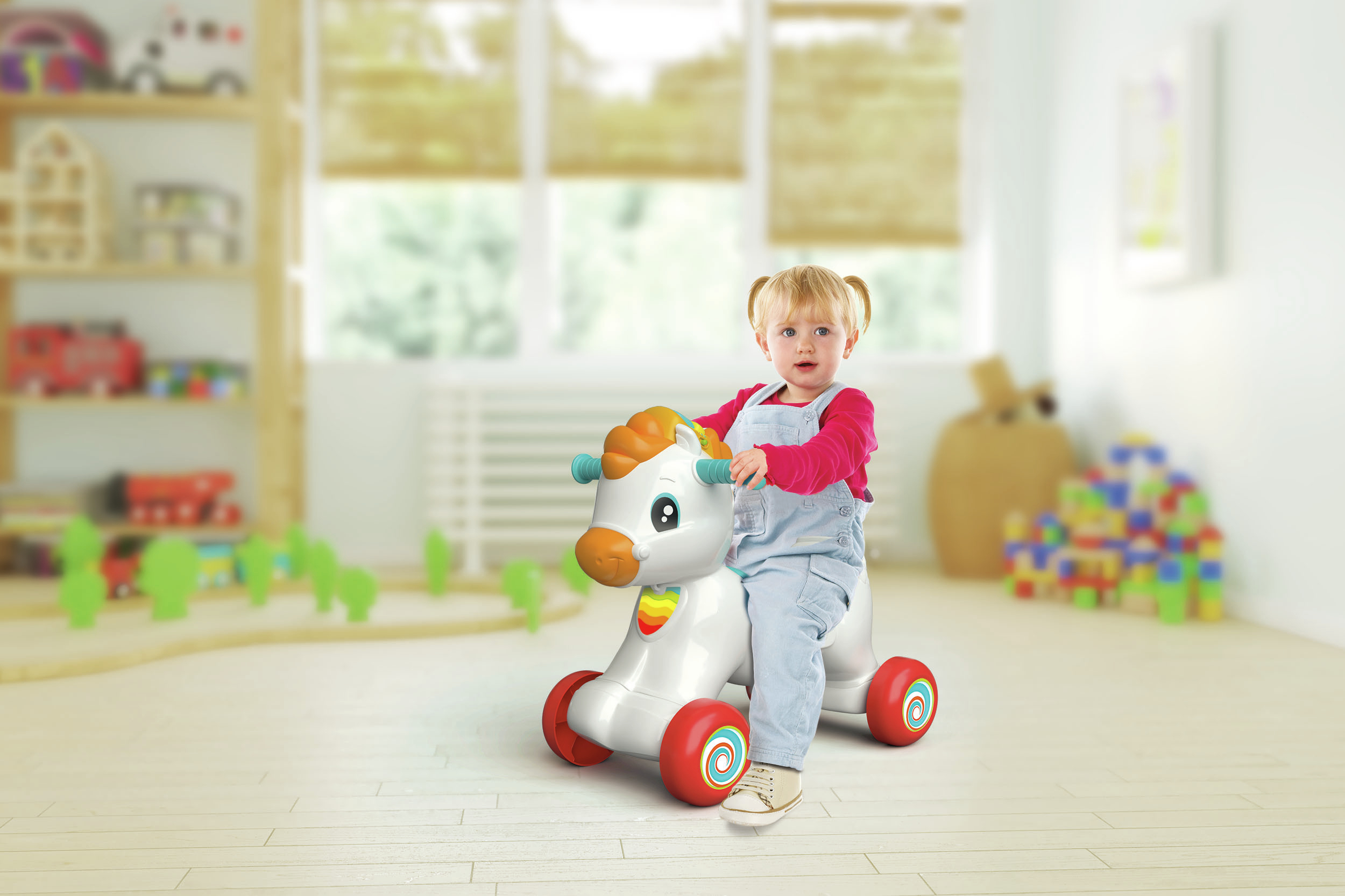 Una bambina cavalca un cavallo giocattolo bianco. Lo sfondo è sfocato.