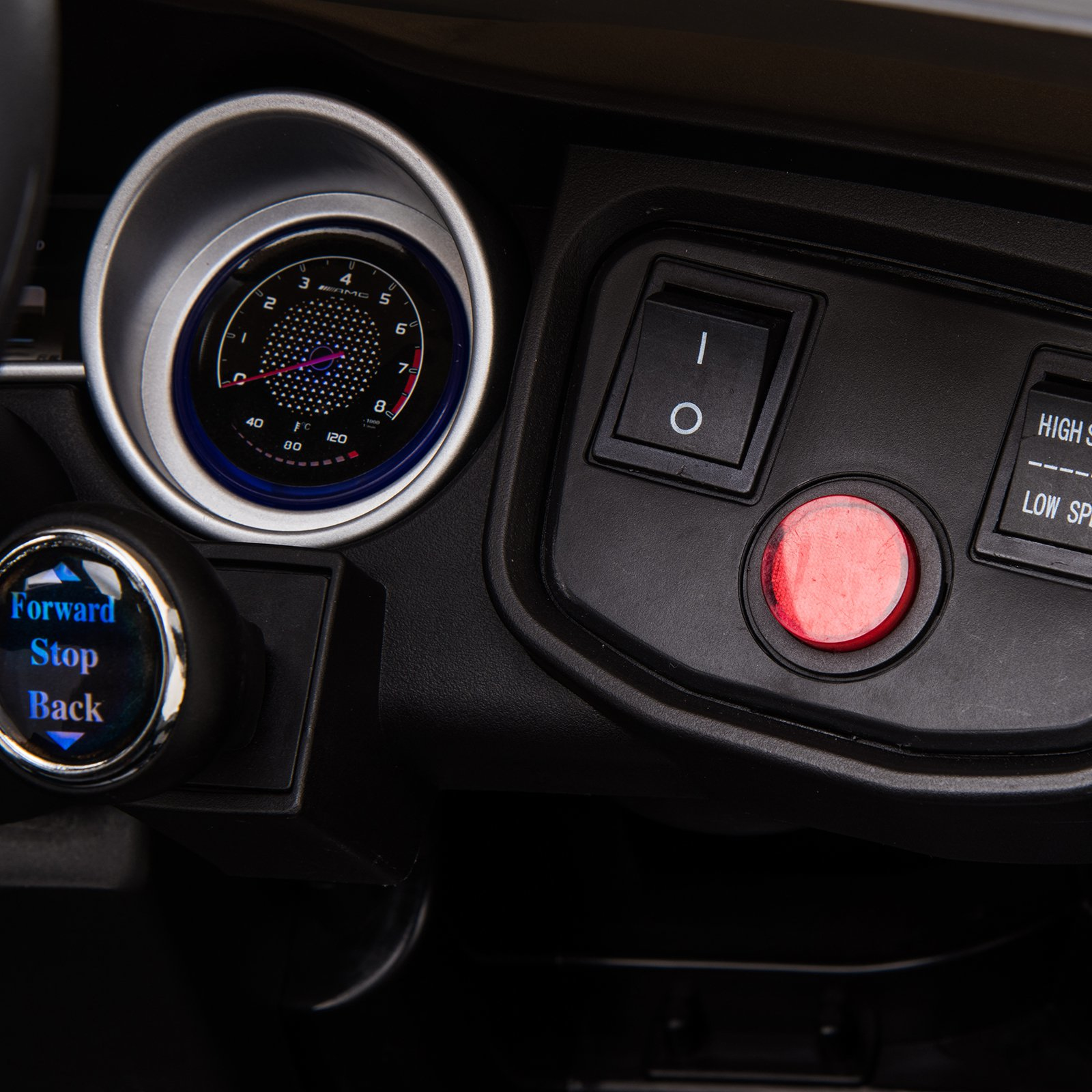 Panel de control del coche con medidores, botones y volante. Muestra controles de avance, parada y retroceso.