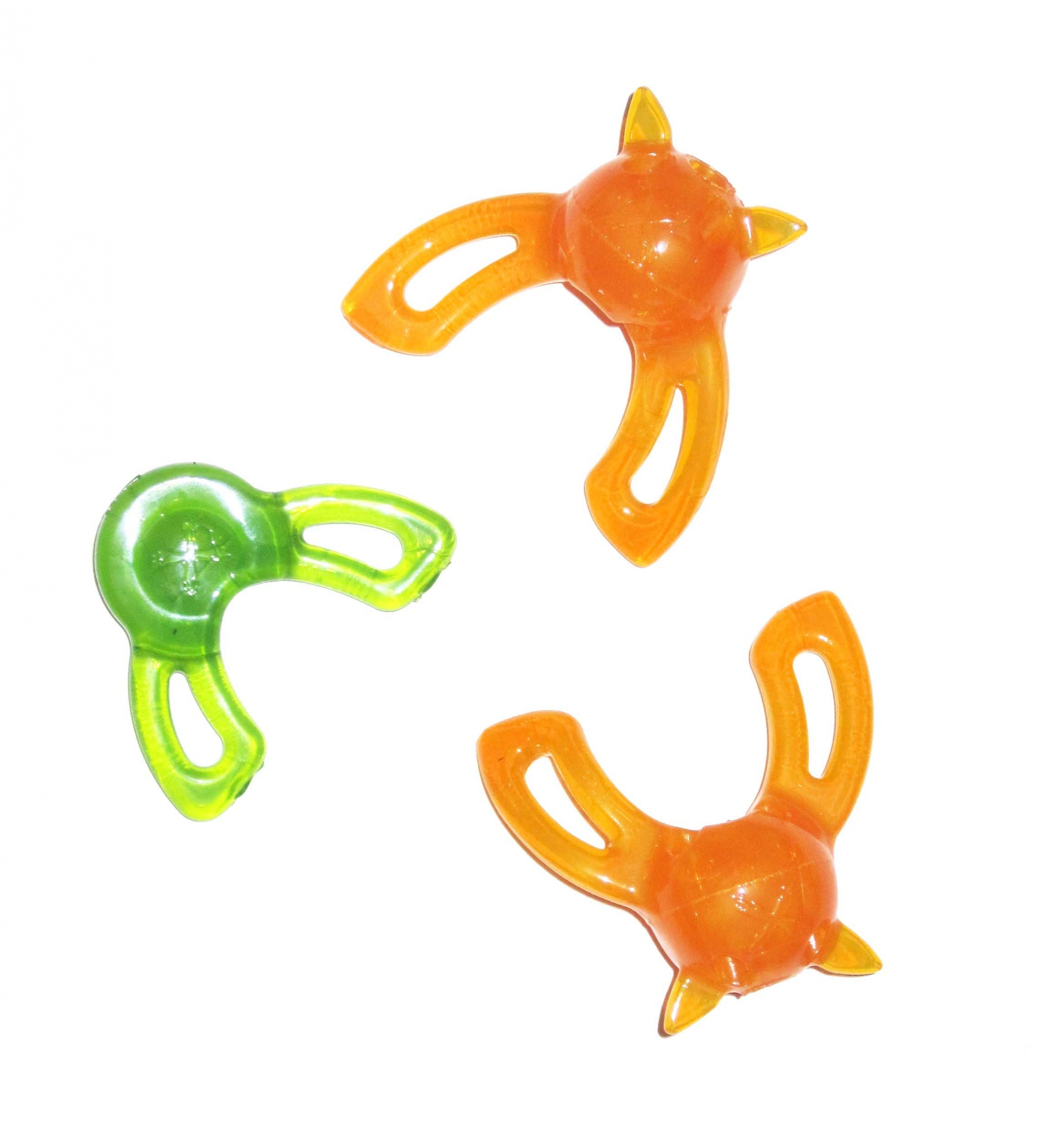 Tres juguetes en forma de estrella naranja y verde. Dos son naranjas, uno verde. Aislados sobre fondo blanco.