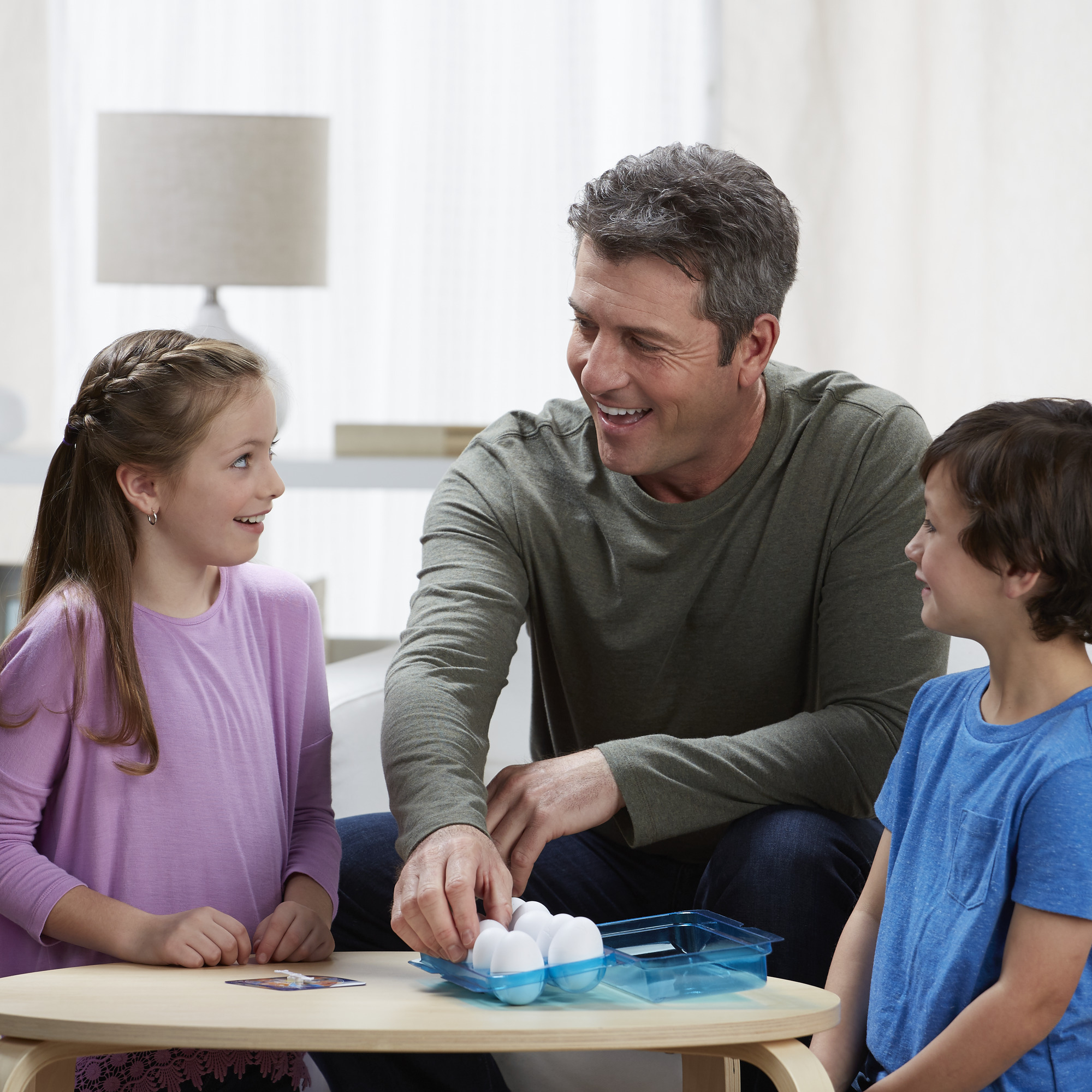 Famiglia che gioca con le uova e una carta da gioco.