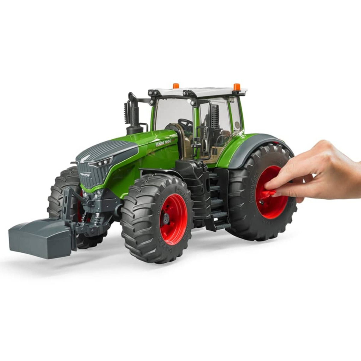 Zabawkowy traktor z ręką obracającą czerwone koło. Traktor jest zielony z czerwonymi kołami.