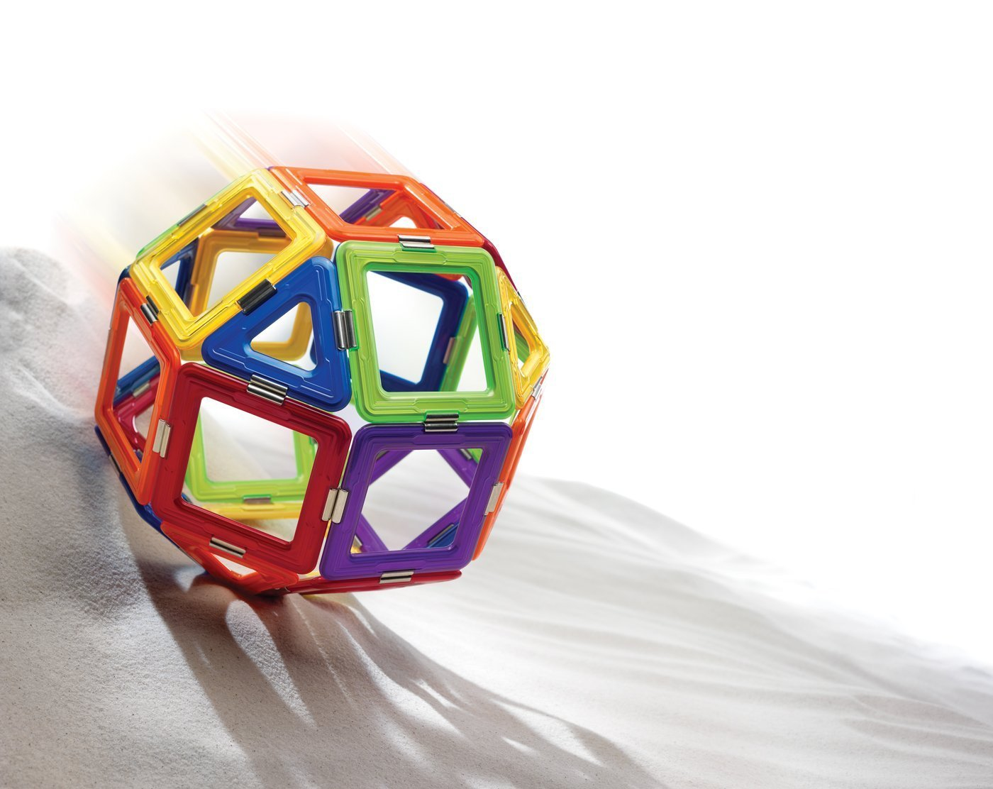Una forma geometrica colorata vola nell'aria sopra la sabbia. Un mix di forme.