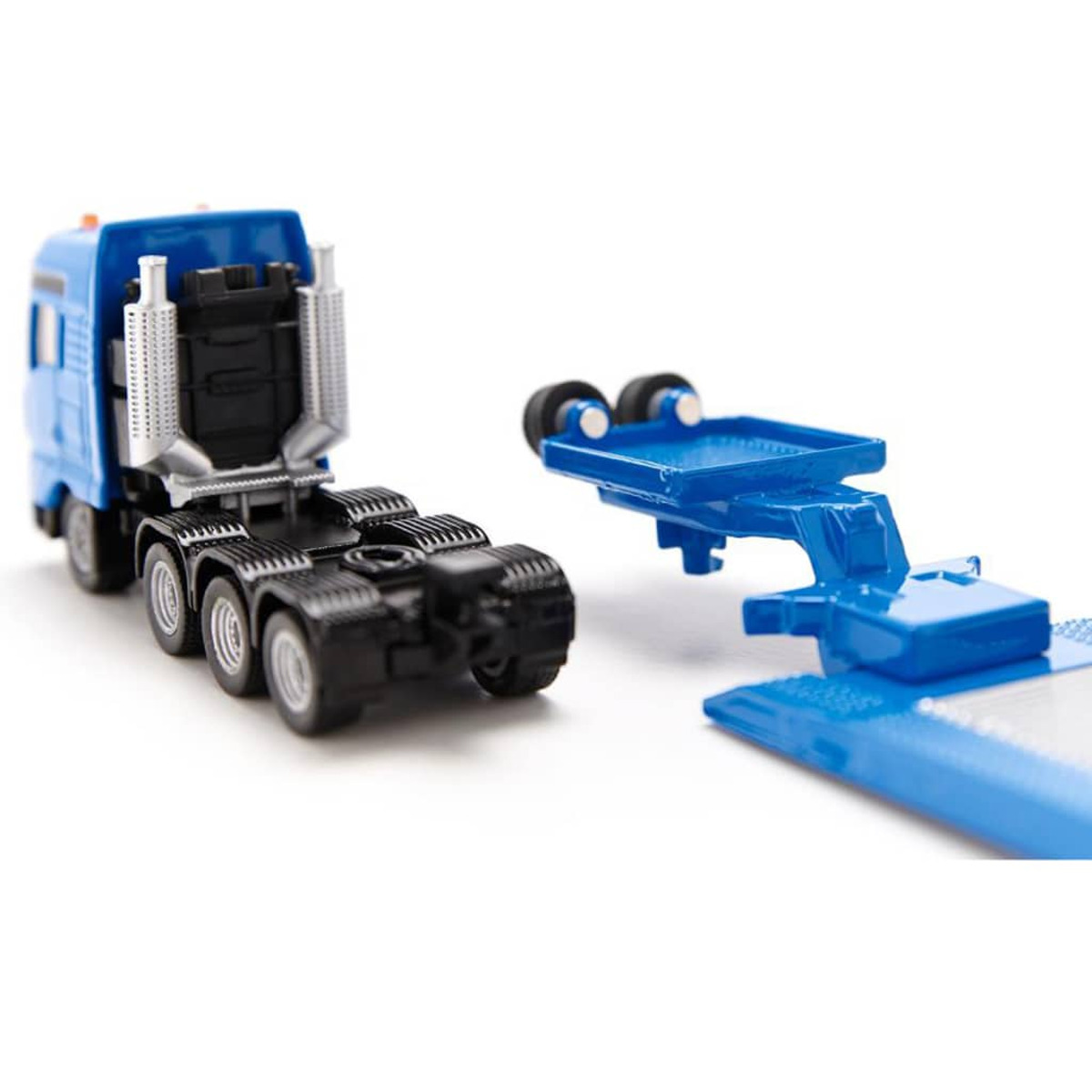 Ein blauer Spielzeug-LKW und ein blauer Anhänger sind getrennt. Der LKW hat silberne Details. Weißer Hintergrund.