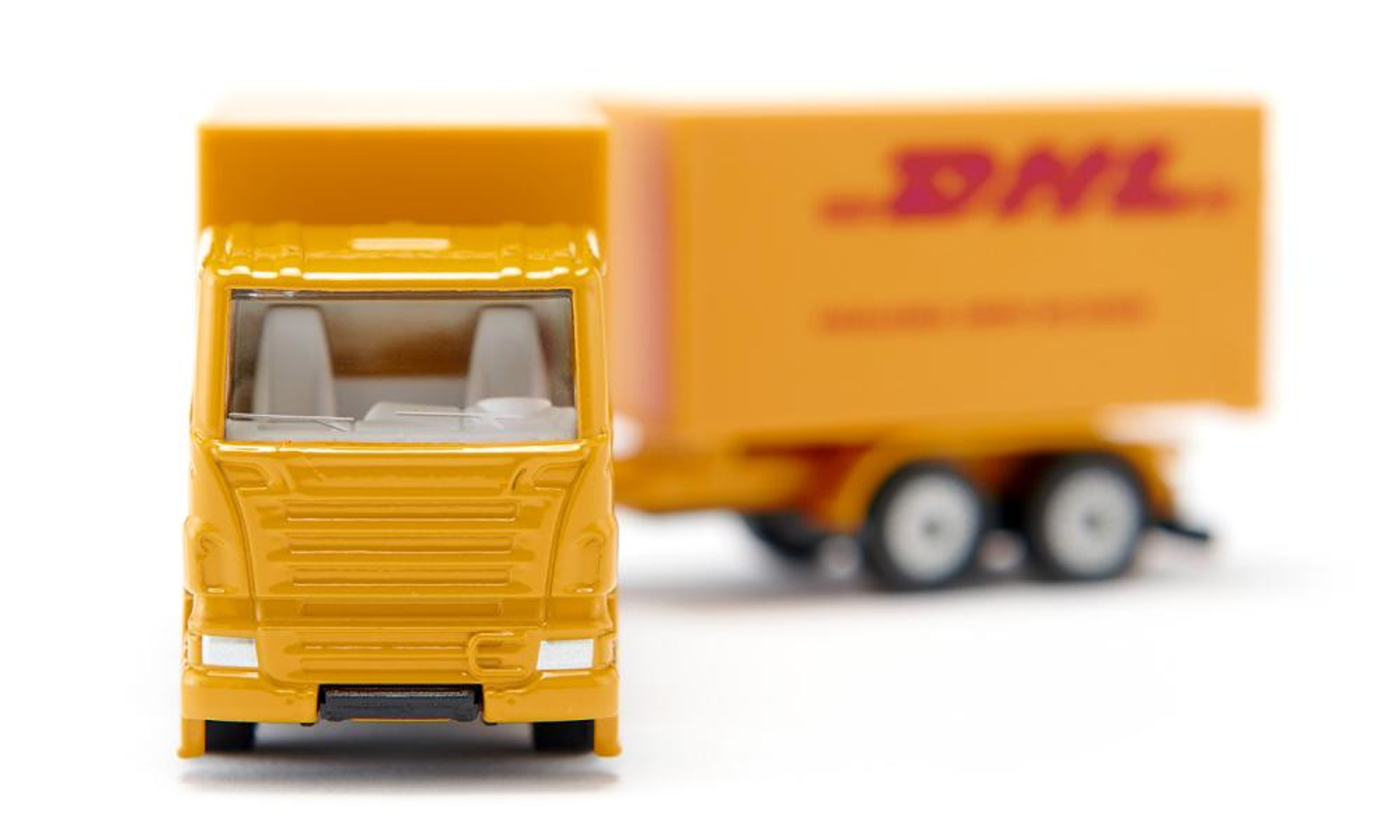 Gelber DHL-LKW und Anhänger. Das DHL-Logo ist auf dem Anhänger sichtbar. Weißer Hintergrund.