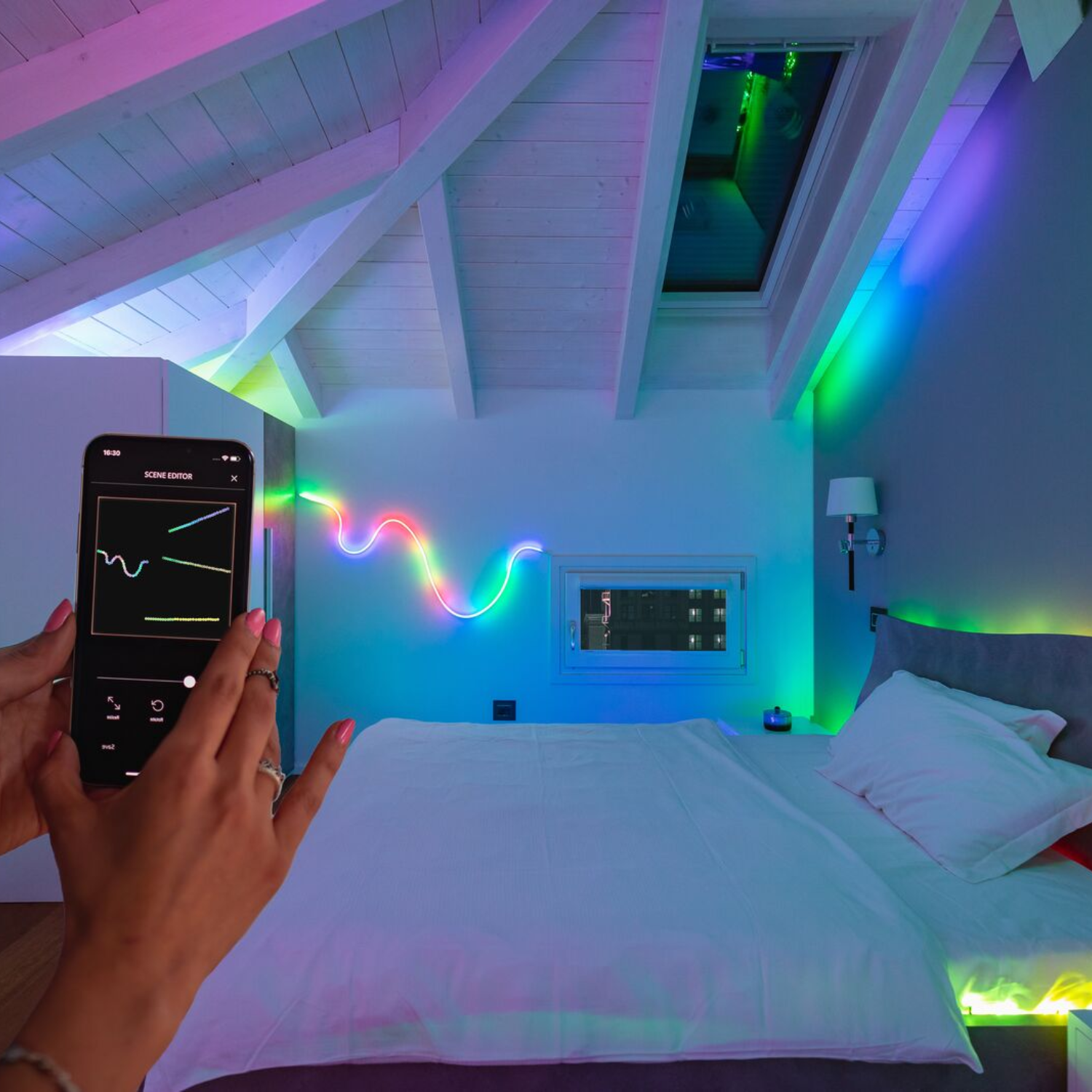Une chambre avec une installation lumineuse au néon colorée. Une personne utilise un téléphone pour contrôler les lumières.