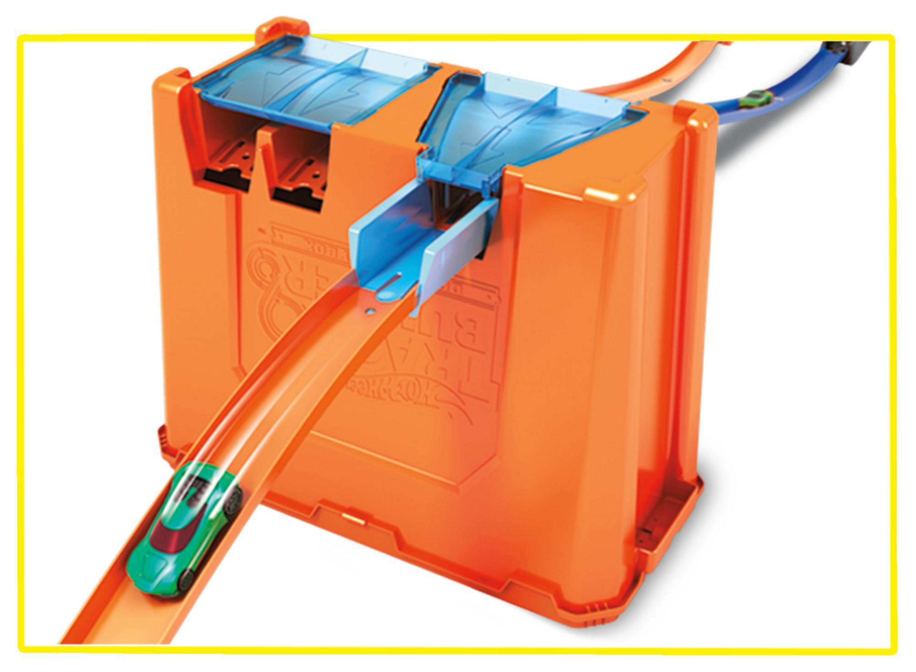 Zestaw torów Hot Wheels. Pomarańczowe pudełko z zielonym samochodem wjeżdżającym na niebieski tor.