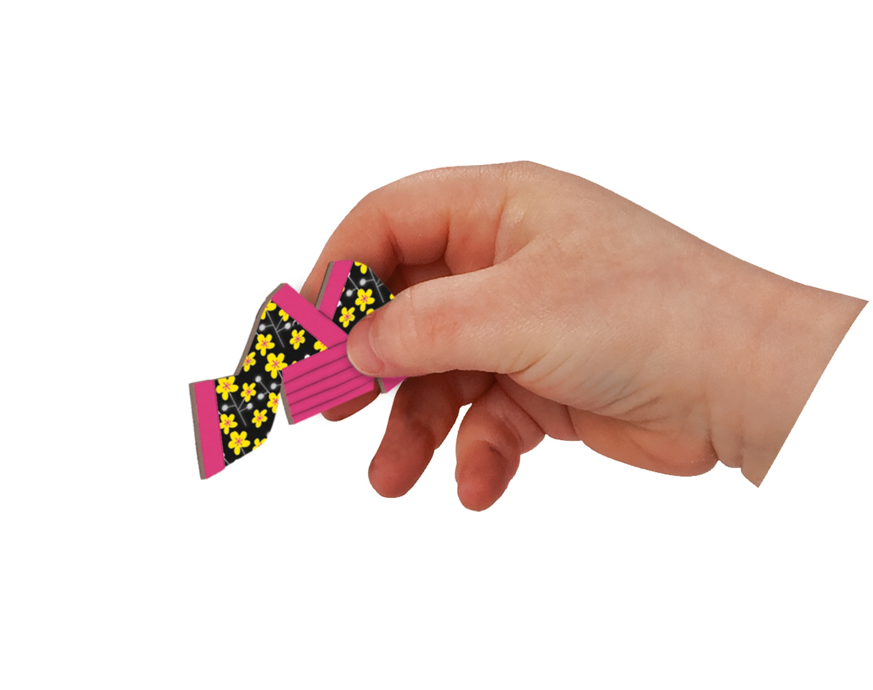 Dłoń trzymająca mały, różowo-żółty, złożony kształt papieru z czarnym kwiatowym wzorem.