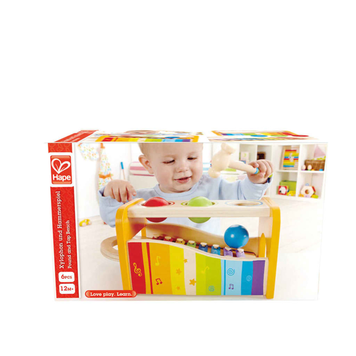 Ein Kind spielt mit einem hölzernen Xylophon-Spielzeug. Das Spielzeug ist bunt, mit einem Hammer, die Box ist im Blick.
