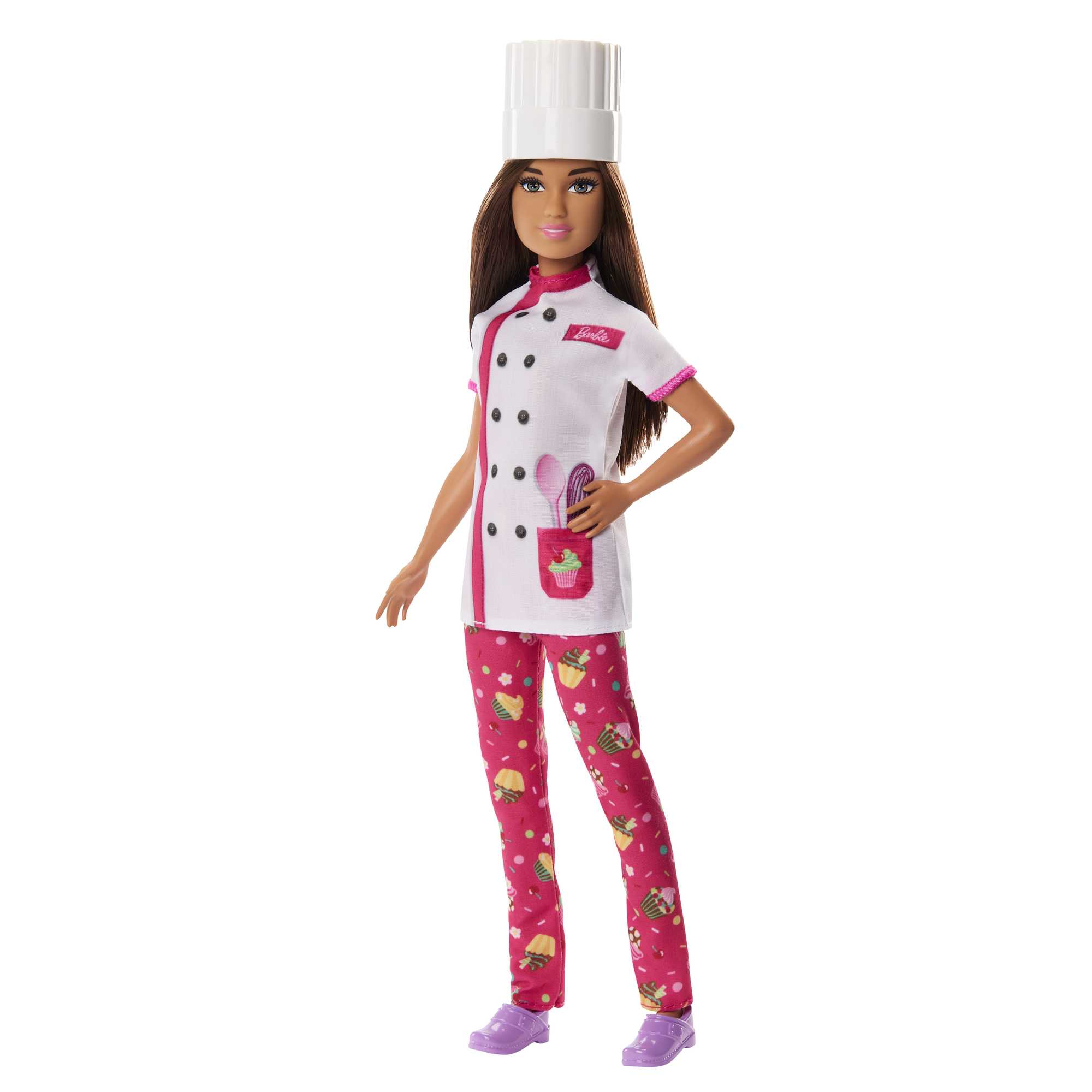 Chef Barbie-Puppe in Uniform. Weißer Kochhut und Jacke, rosa Hose mit Cupcake-Muster. Hält Utensilien.