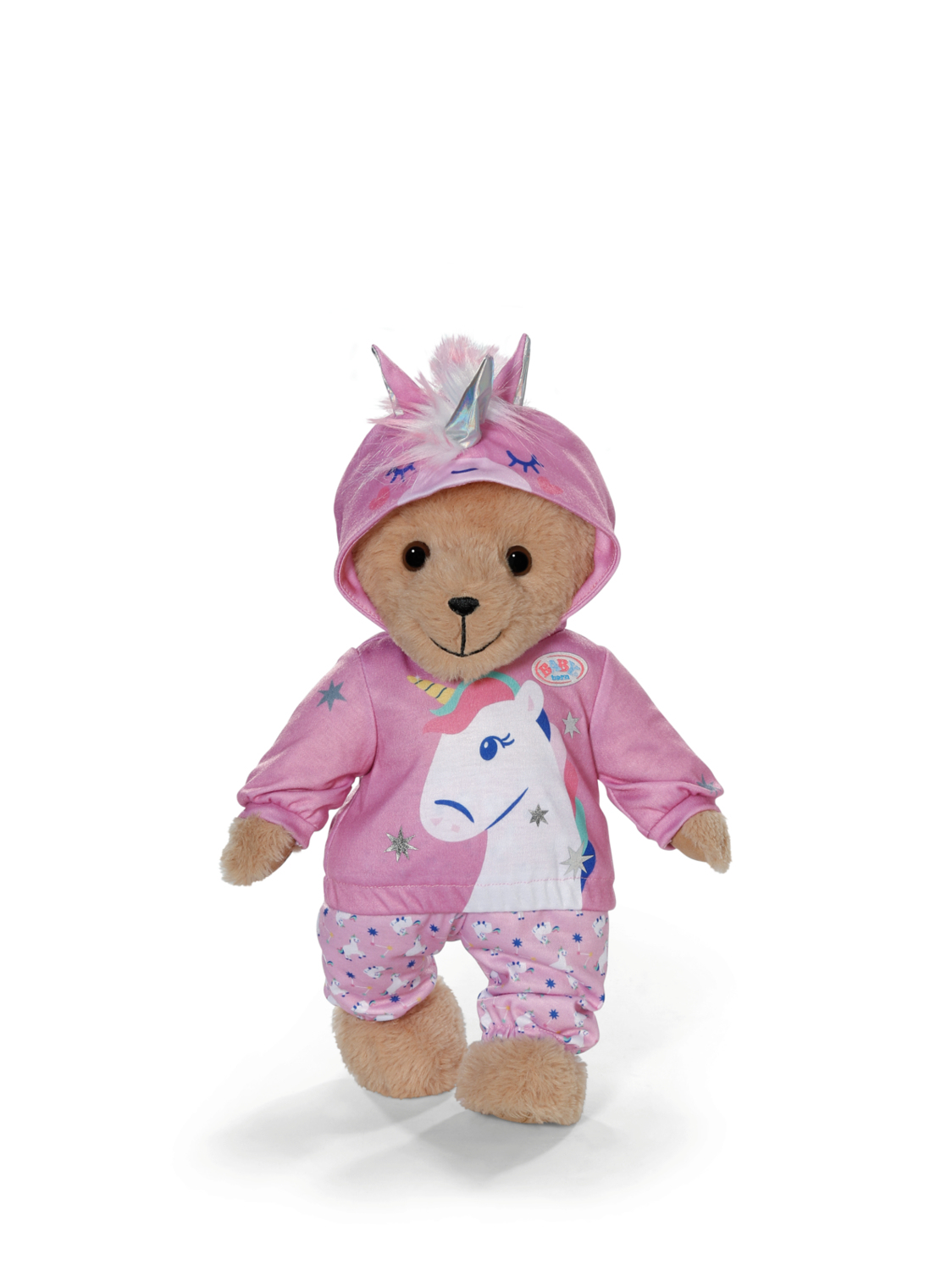 Miś w różowej piżamie z jednorożcem i pasującym kapturze, na białej powierzchni.
