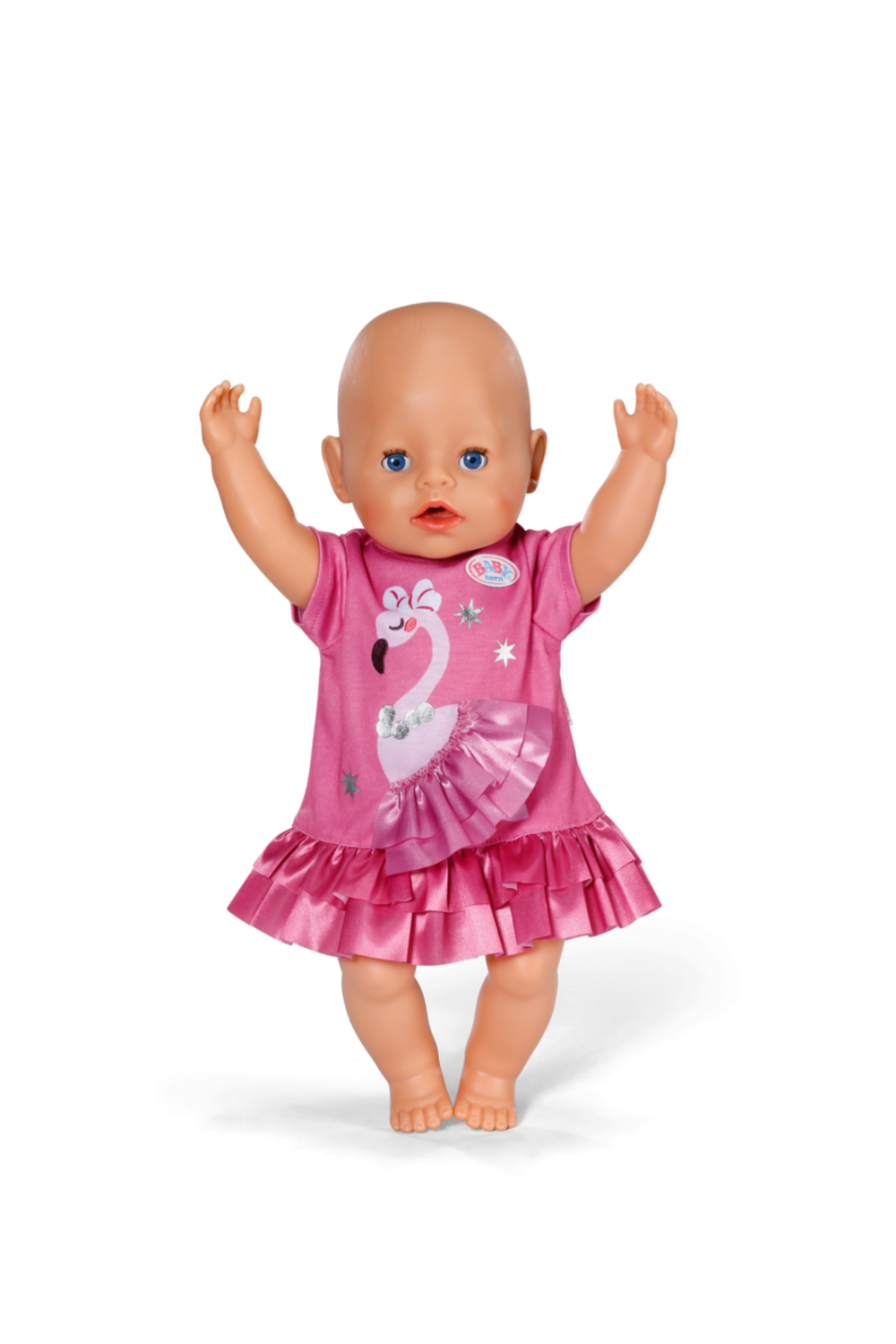 Lalka w różowej sukience z flamingiem, ręce w górze. Białe tło.