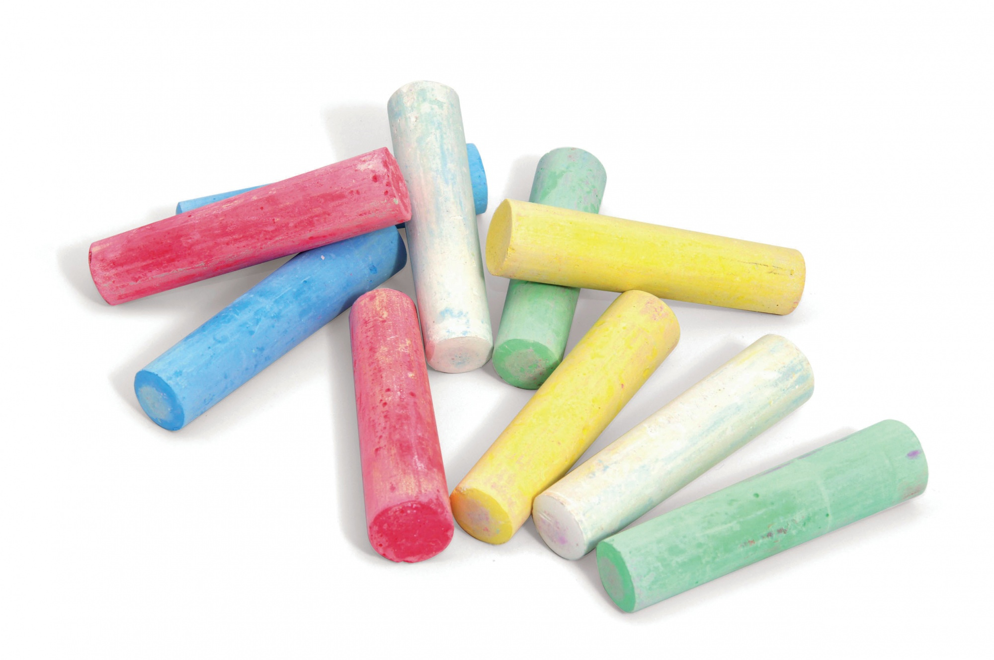 Rozrzucone kolorowe kredy na białej powierzchni. Różne kolory to czerwony, niebieski, żółty, zielony i biały.