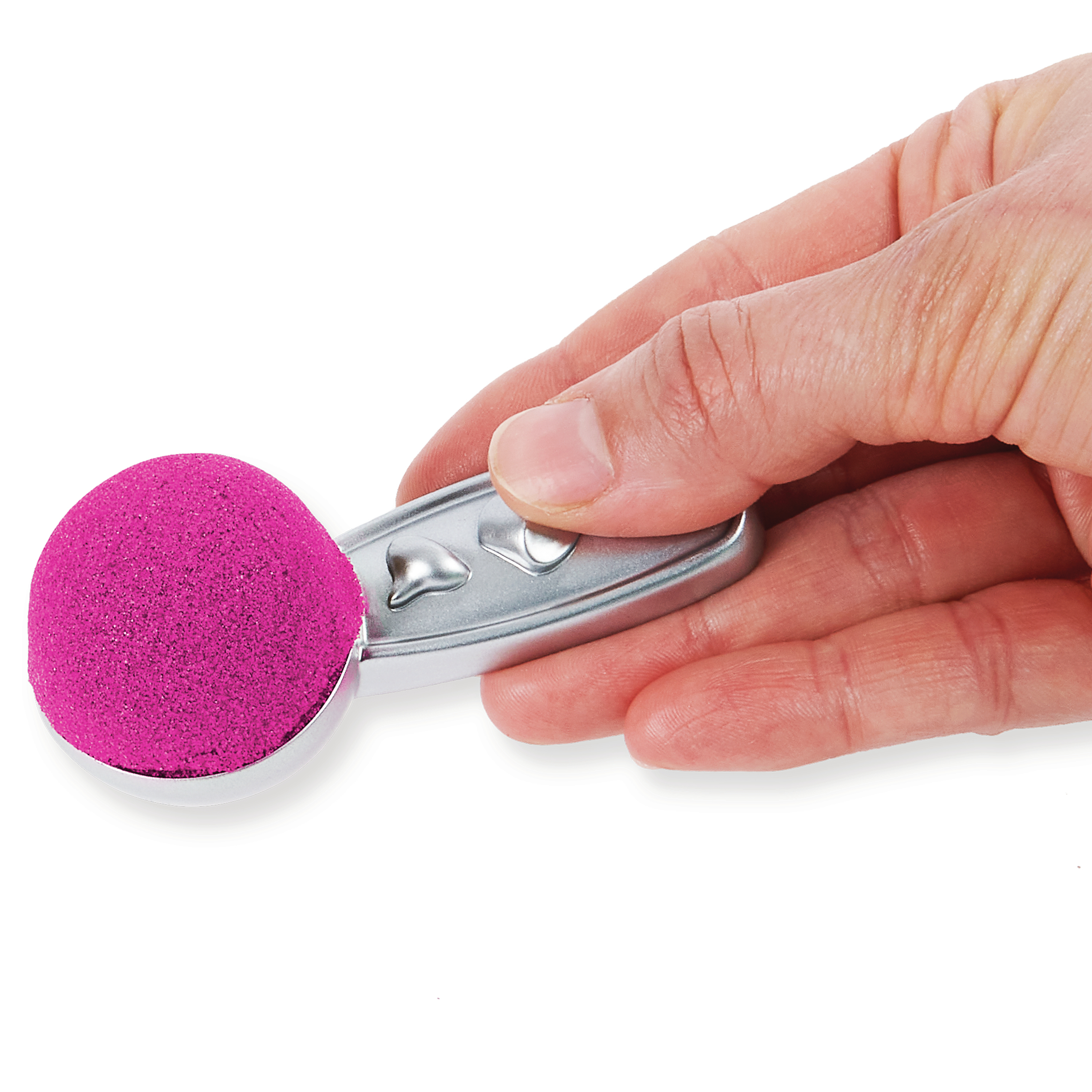 Una mano sosteniendo una cuchara llena de arena rosa sobre un fondo blanco.