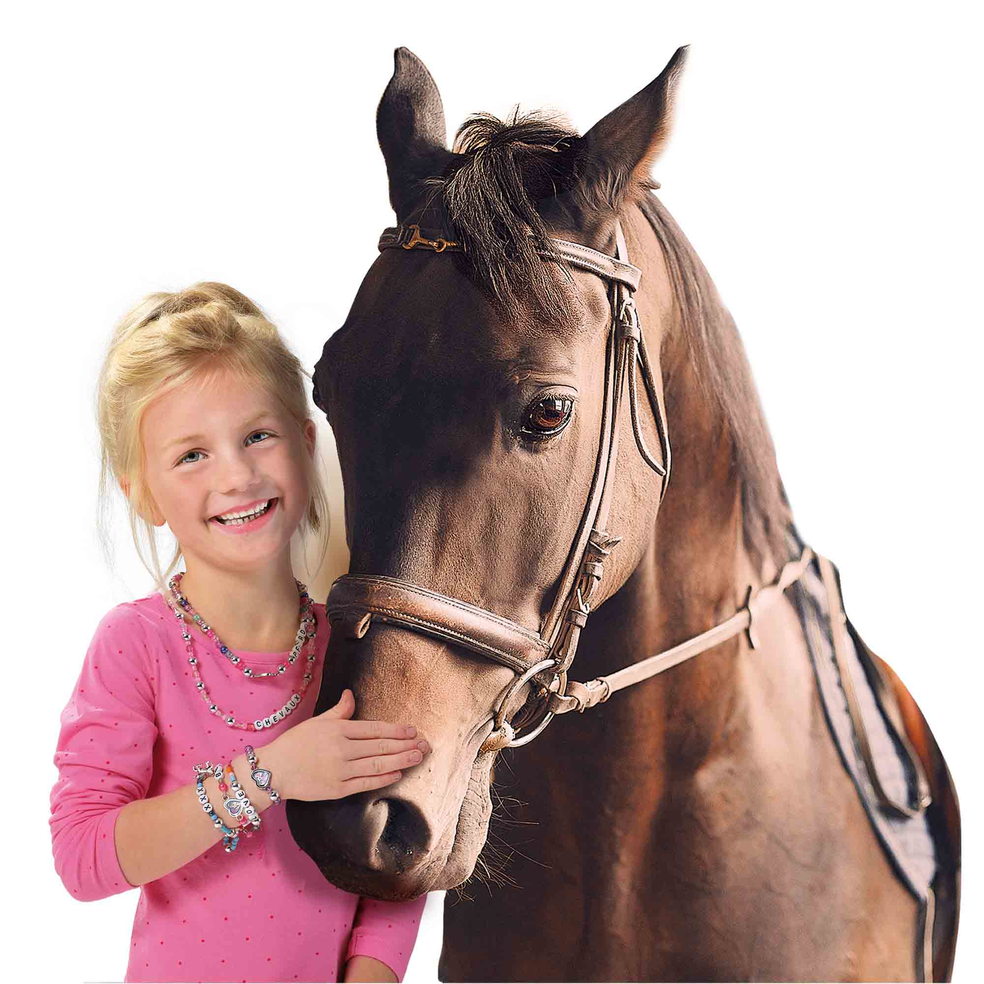 Dziewczynka uśmiecha się obok brązowego konia w uprzęży, z koralikowymi bransoletkami i naszyjnikami.