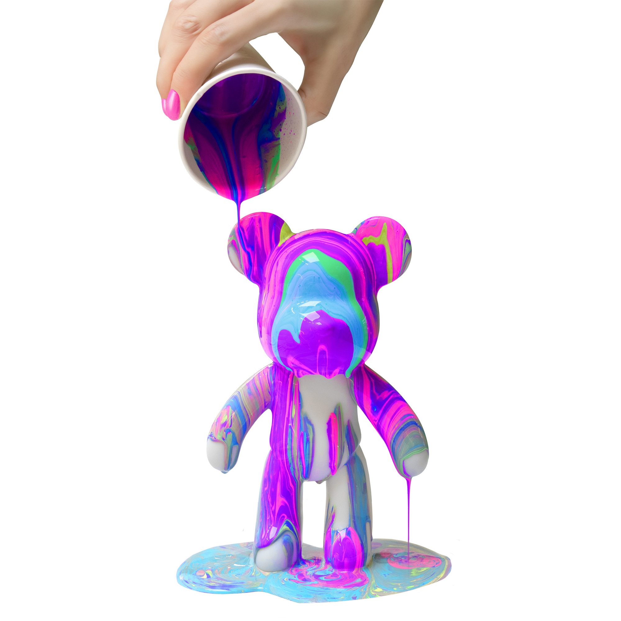 Mano vertiendo pintura sobre una estatua de oso, pintura colorida en el suelo.