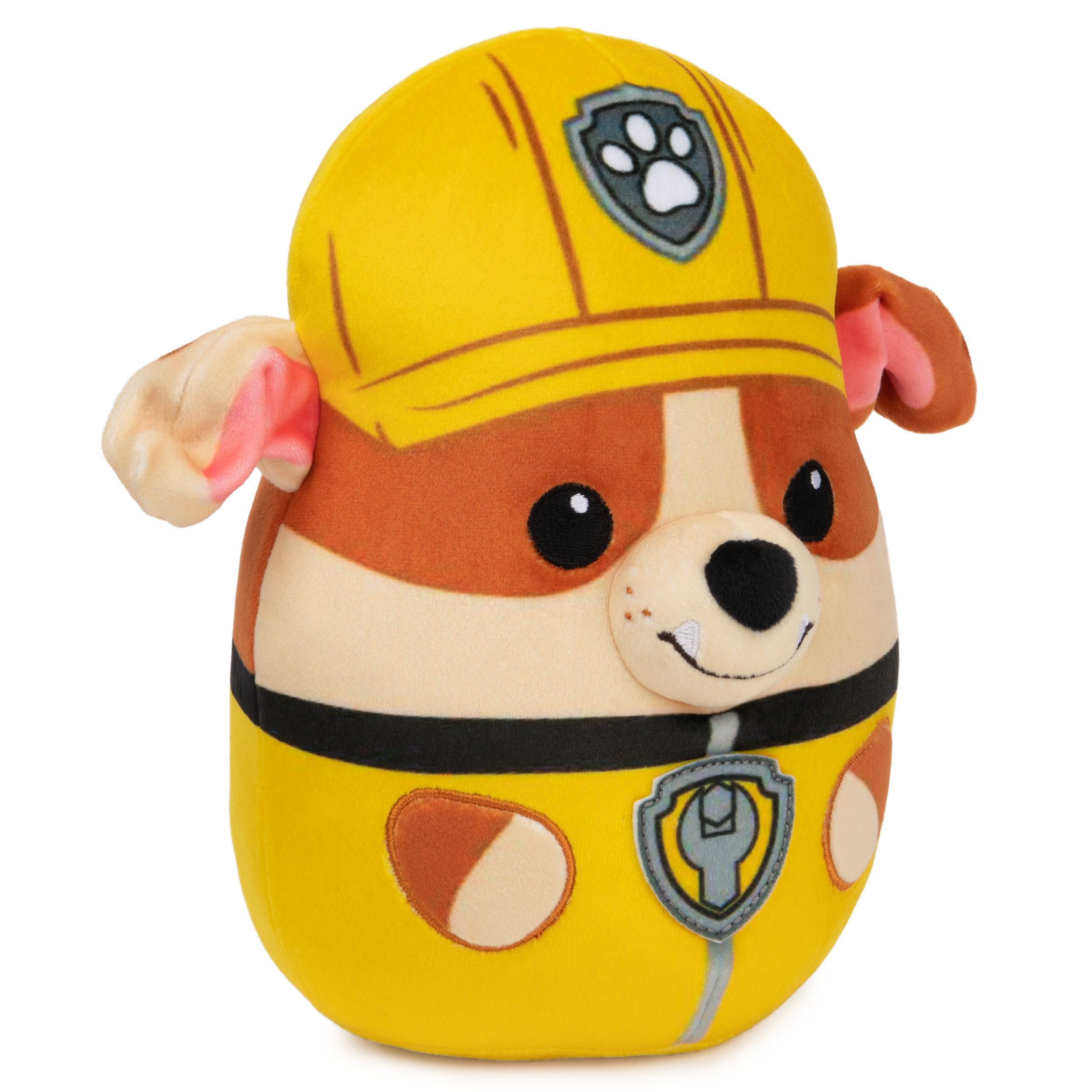 Peluche giallo e marrone di un cane con casco giallo e distintivo. È un giocattolo di Paw Patrol.