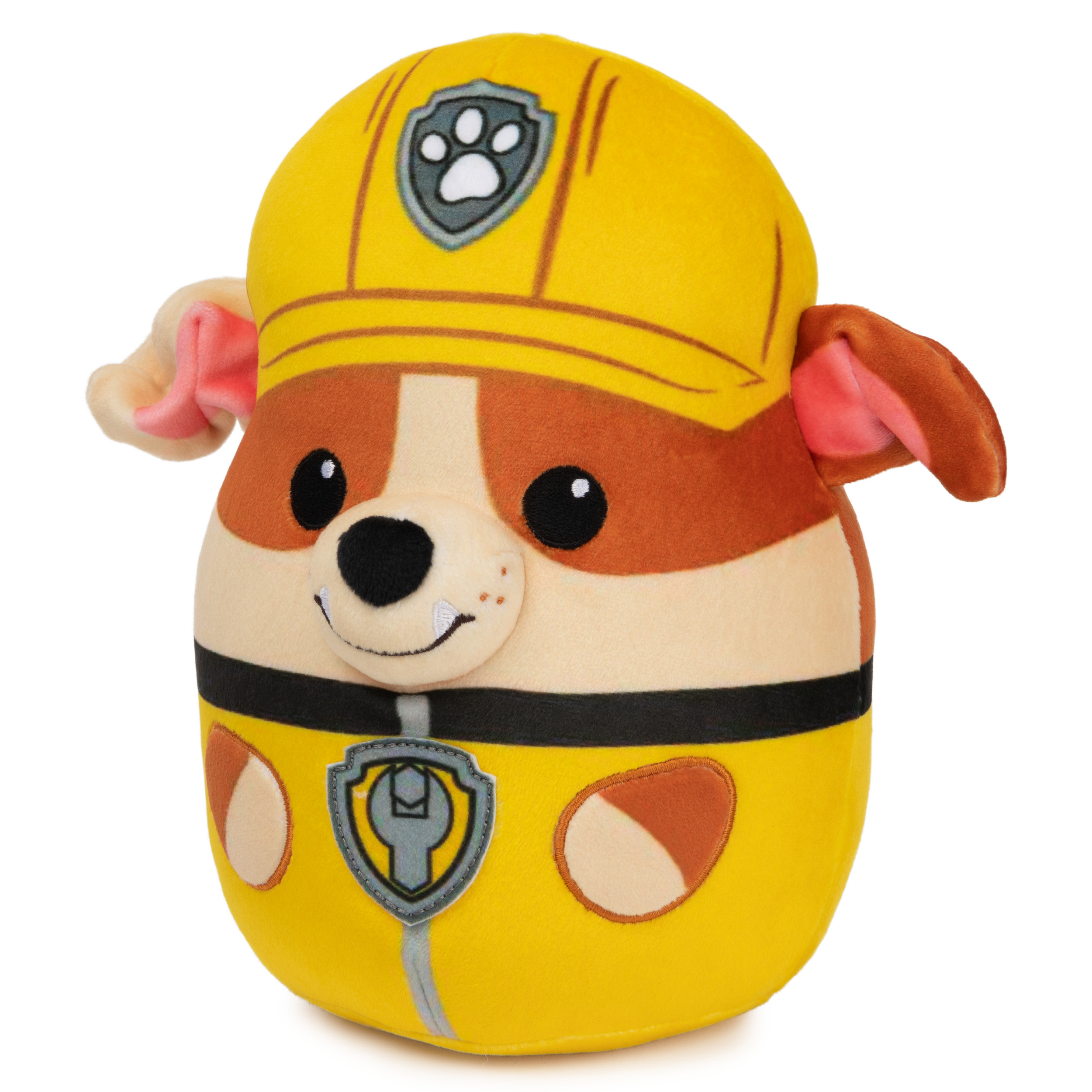 Peluche giallo e marrone di un cane con casco giallo e distintivo. È un giocattolo di Paw Patrol.